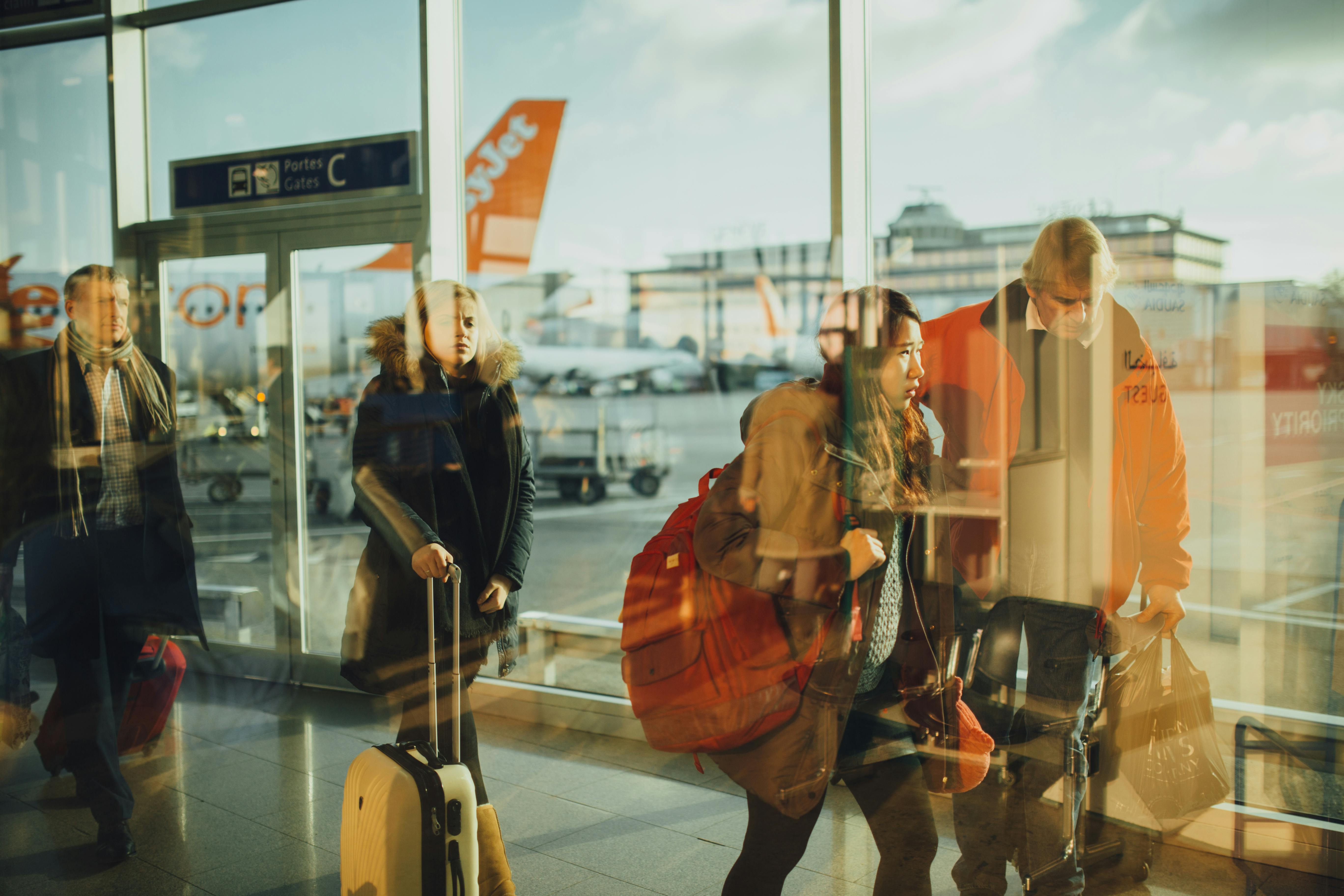 Viajeros abriéndose paso por el vestíbulo de un aeropuerto | Fuente: Pexels