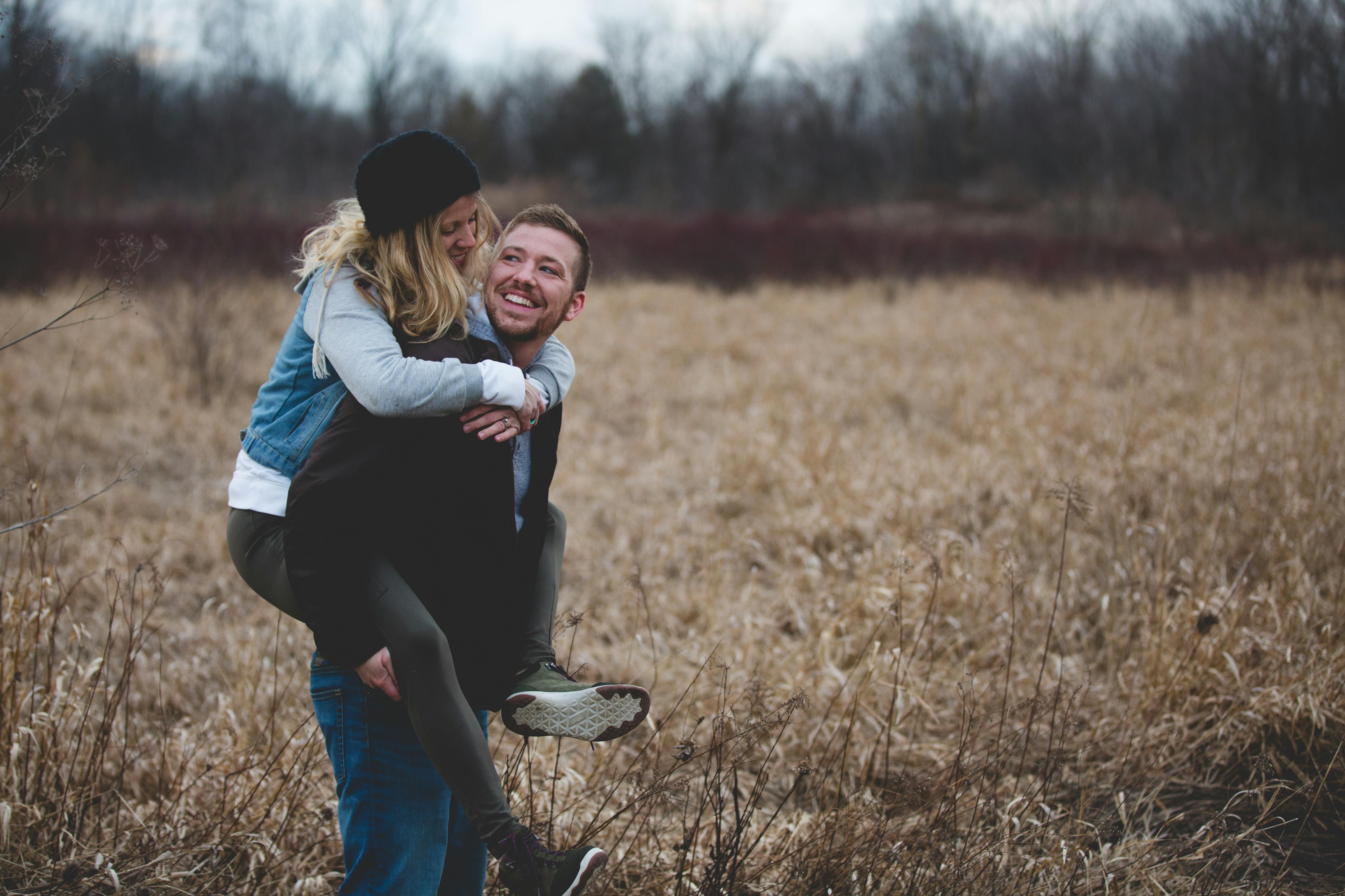 Una pareja feliz en un campo | Fuente: Pexels