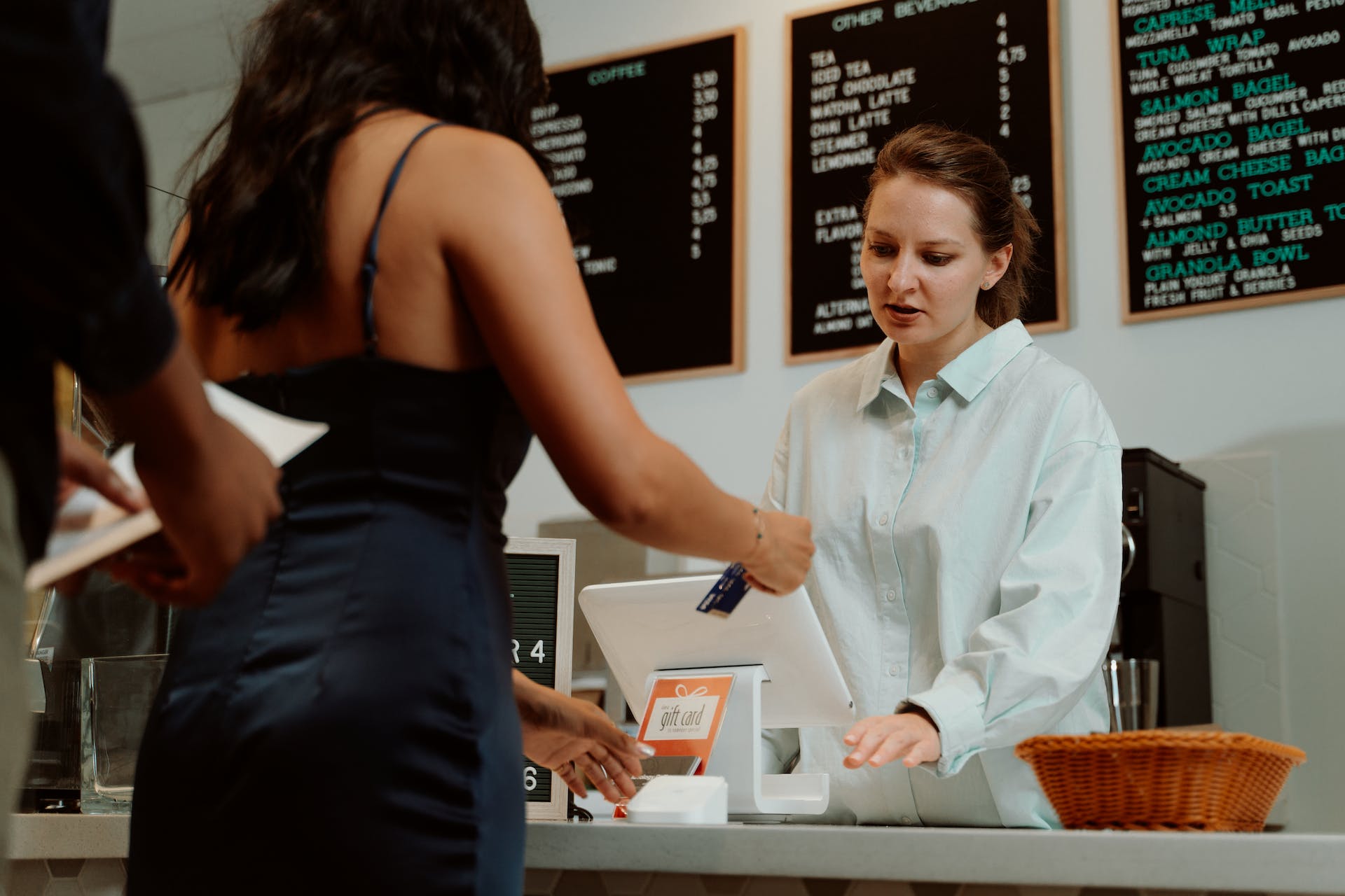 Una cajera en una cafetería interactuando con los clientes | Fuente: Pexels