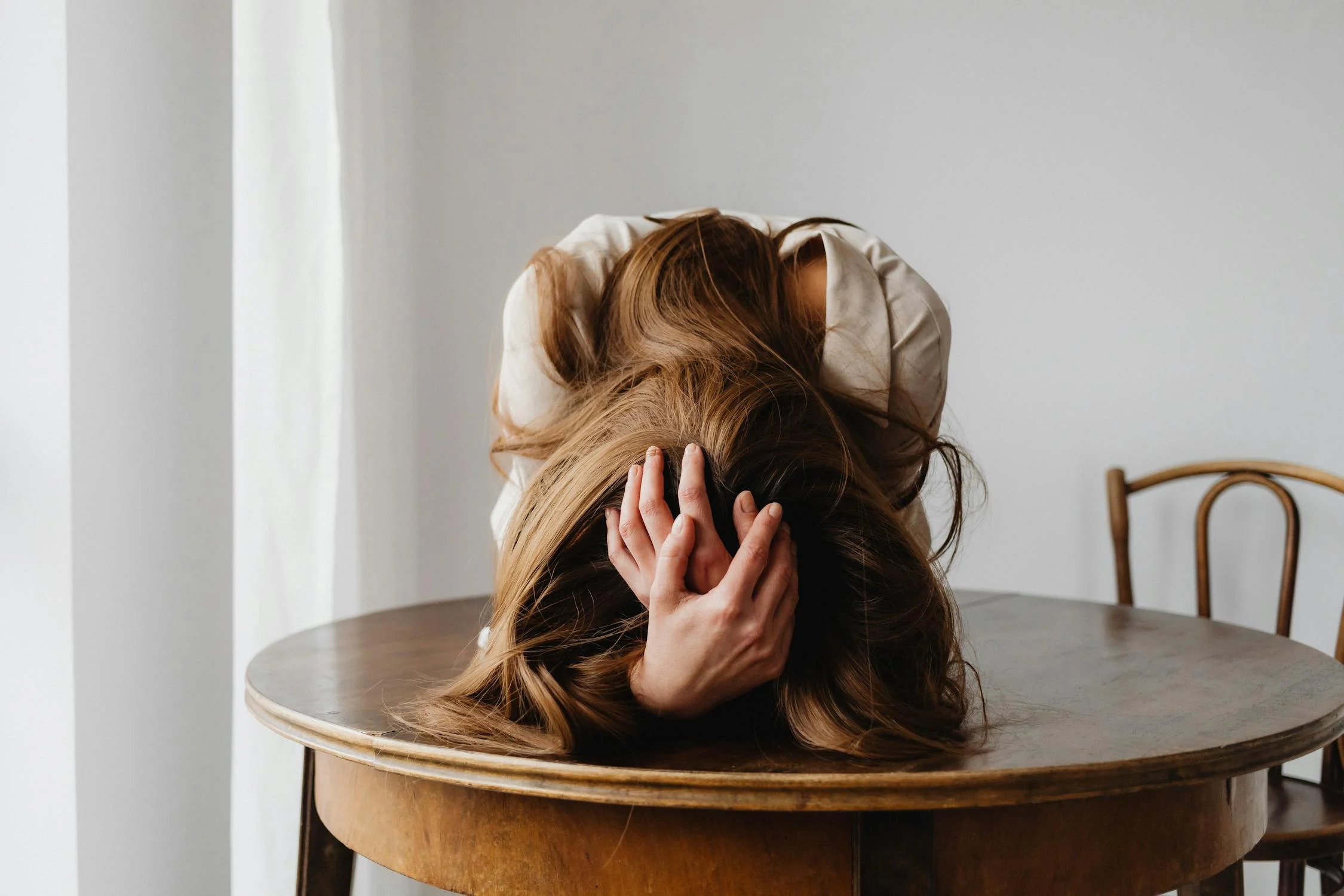 Una mujer cansada sujetándose la cabeza | Fuente: Pexels
