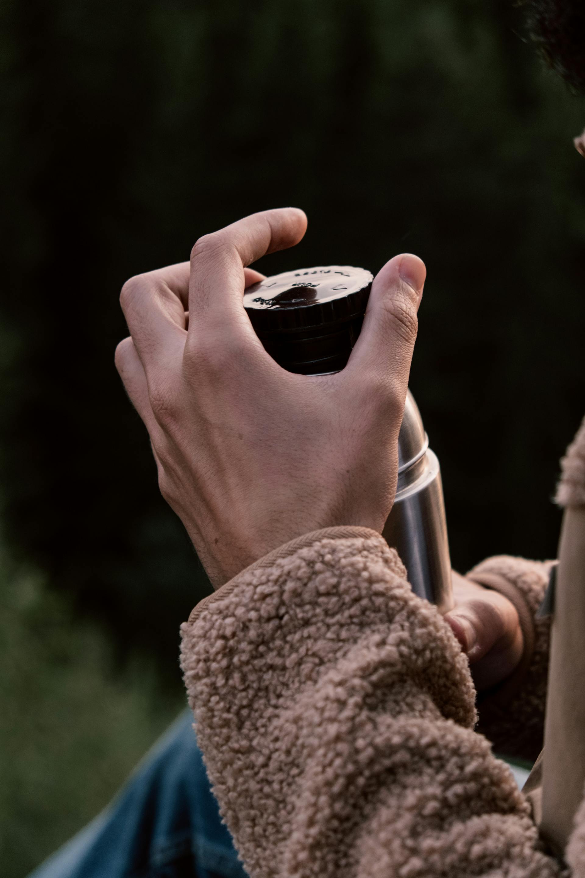 Una persona sujetando una petaca de acero inoxidable | Foto: Pexels
