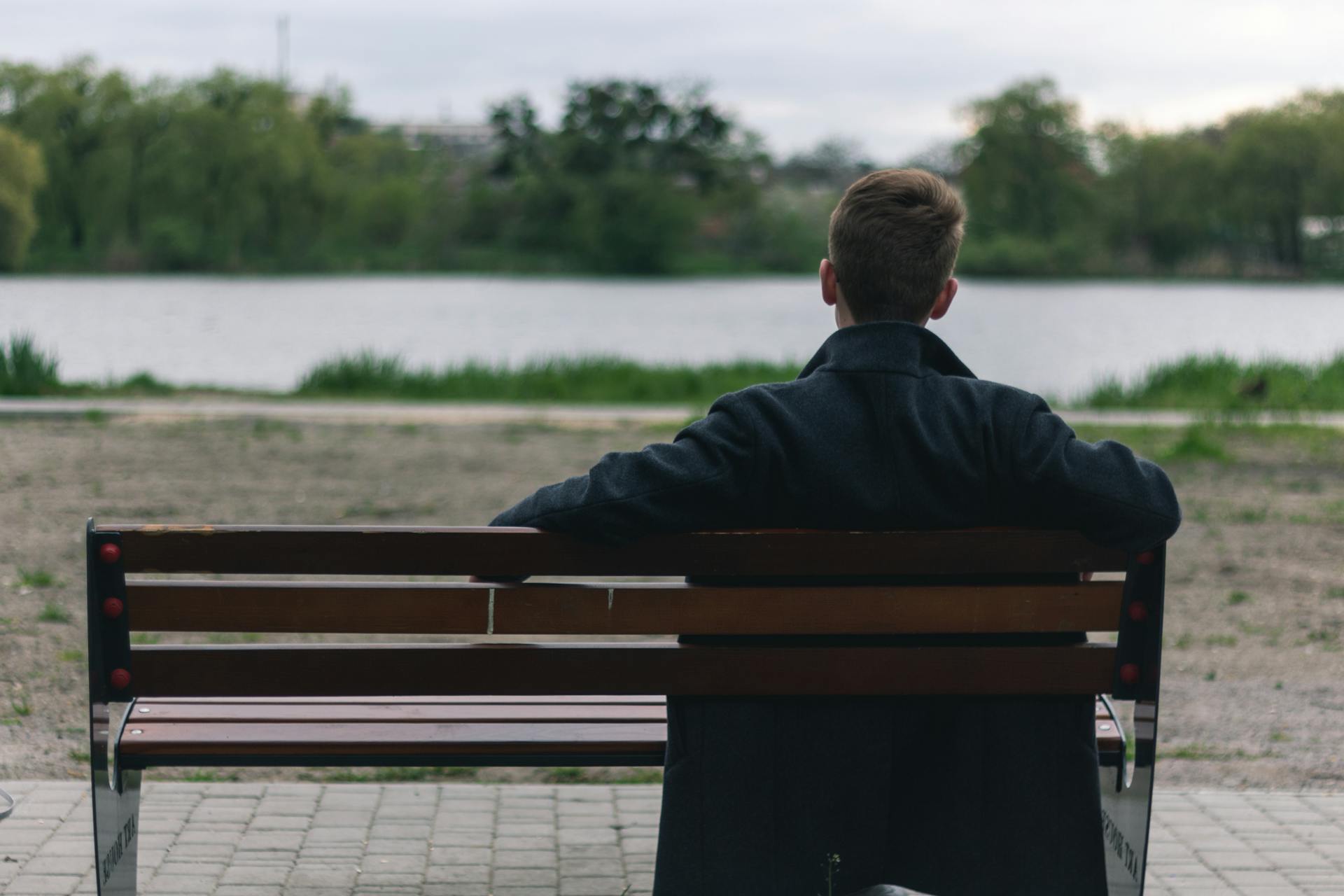 Un hombre sentado en un banco | Fuente: Pexels