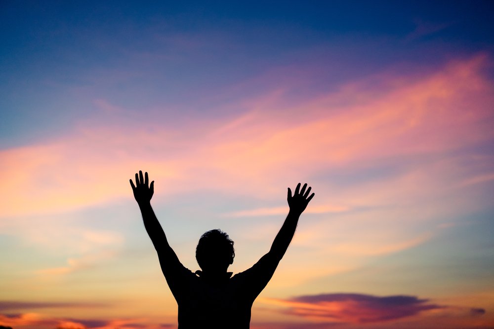 Persona adorando a Dios en el cielo. | Foto: Shutterstock