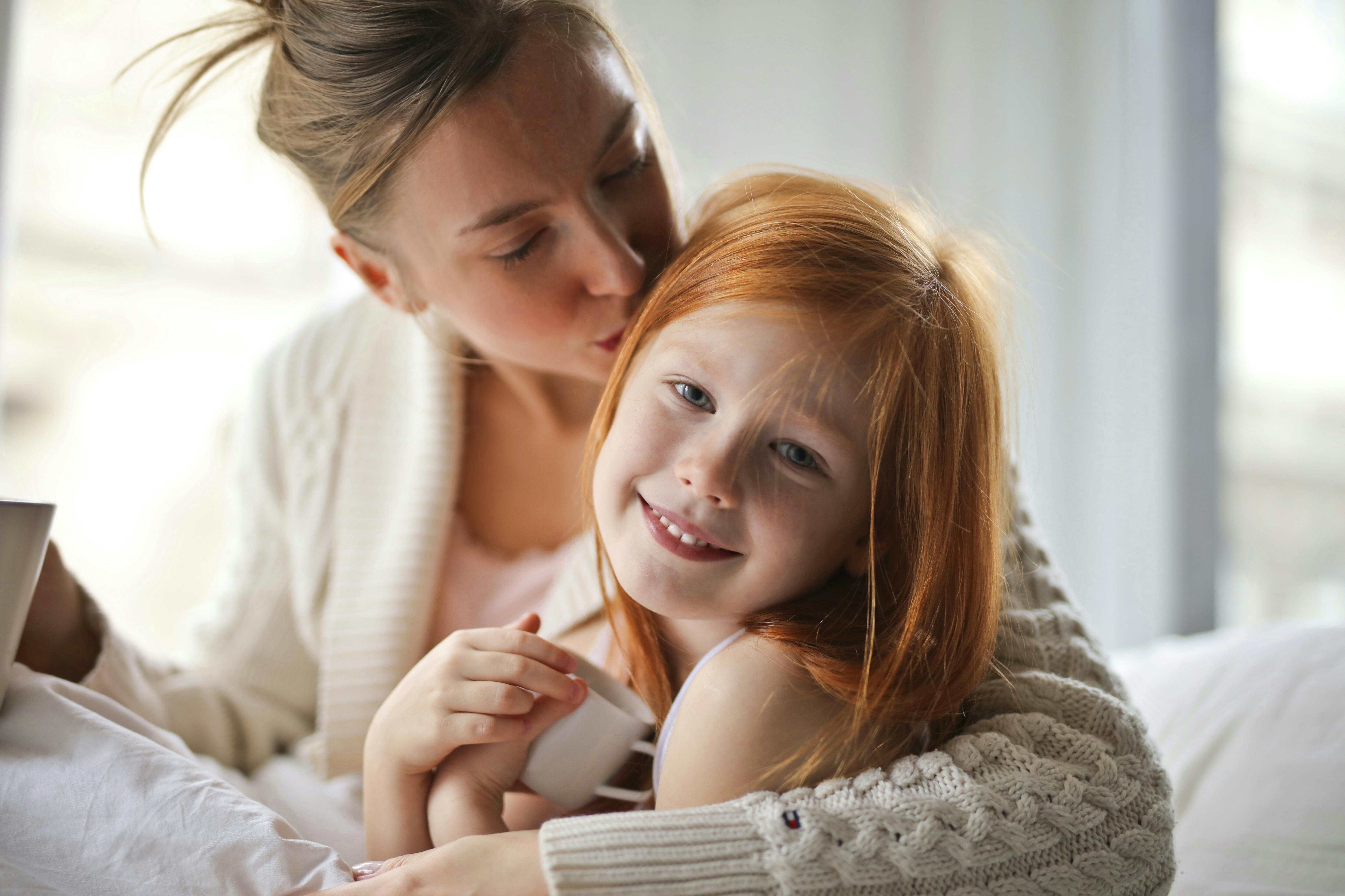 Una madre besando la cabeza de su hijo | Fuente: Pexels