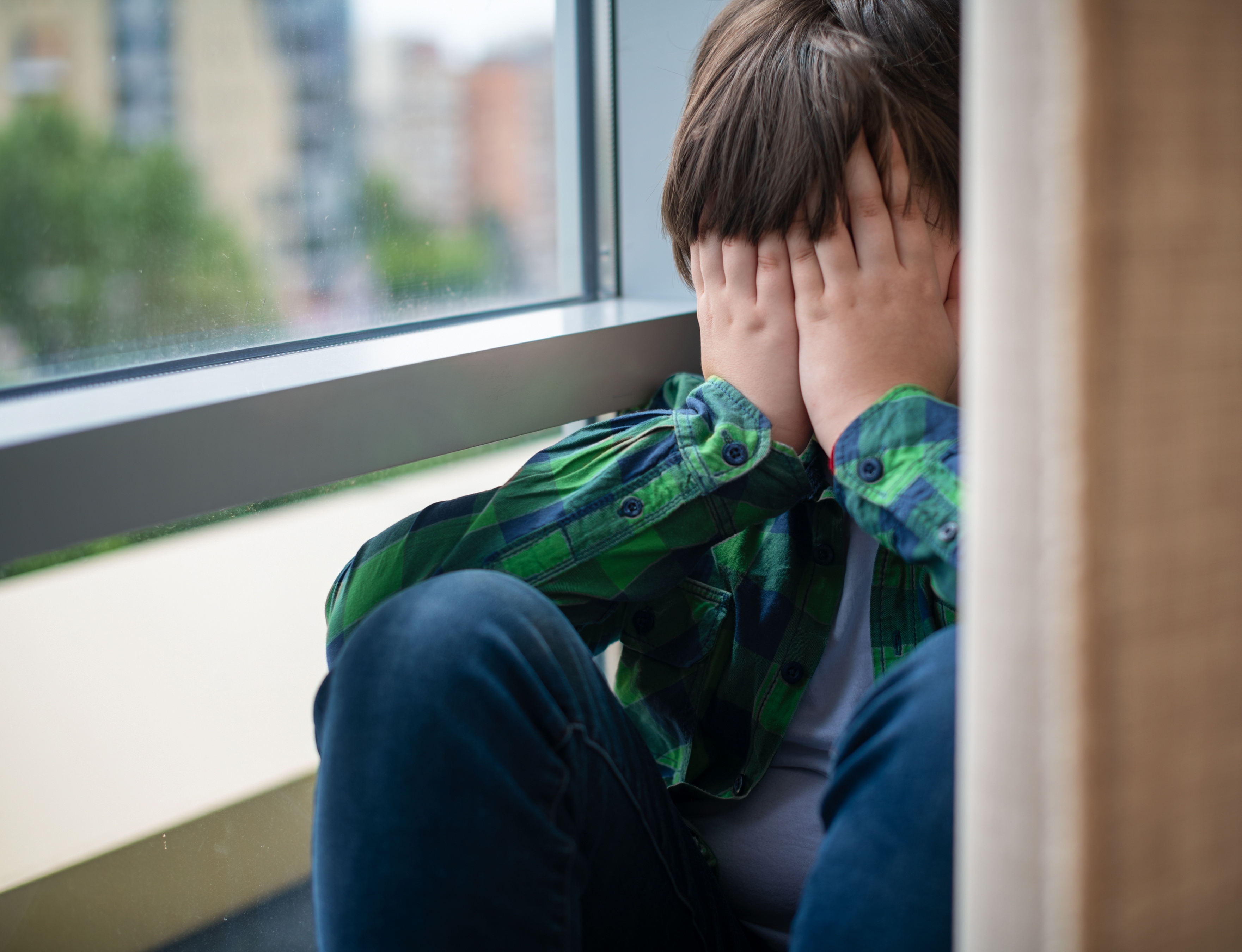 Niño cubriéndose el rostro con las manos. | Foto: Shutterstock