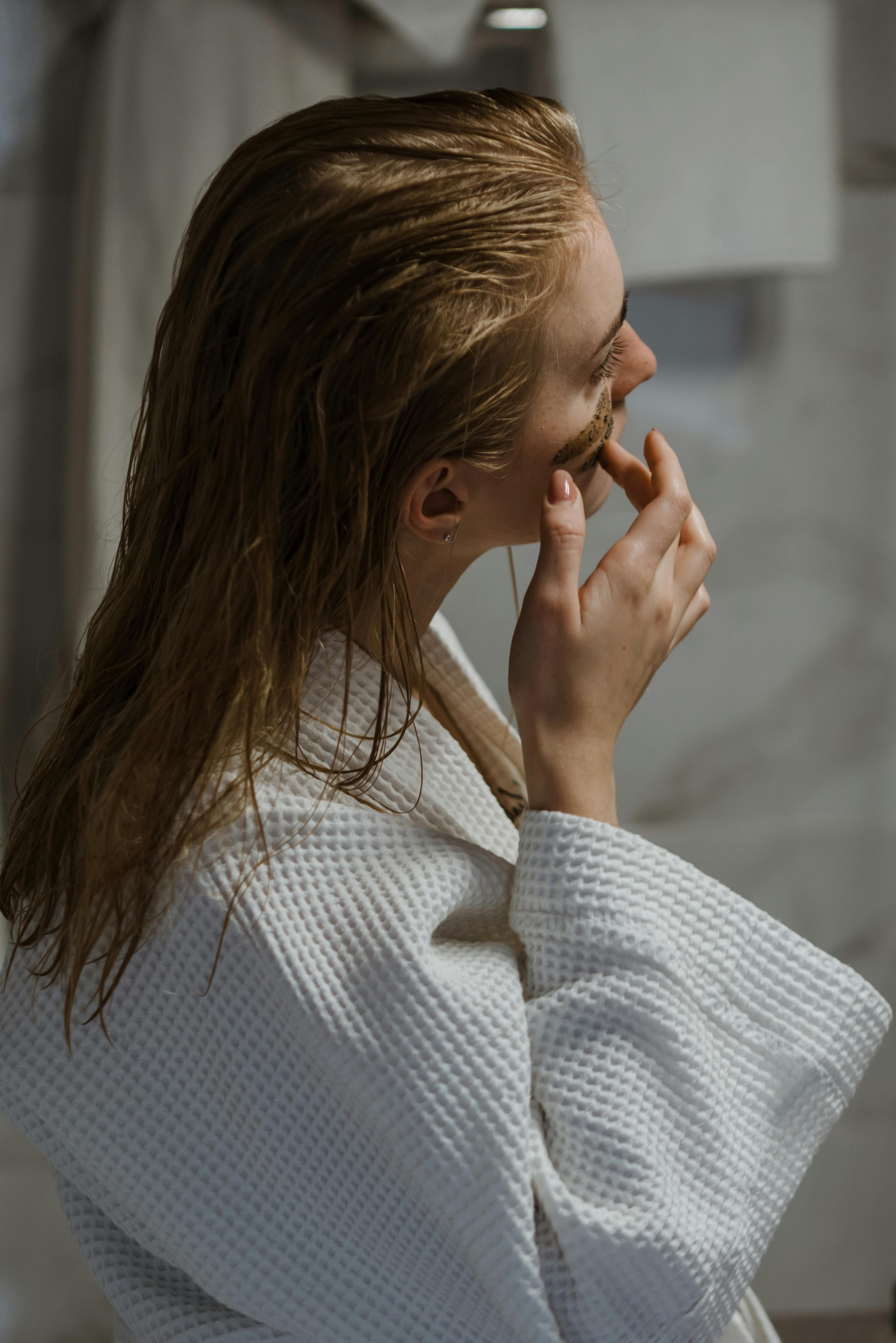 Una mujer aplicándose productos faciales después de ducharse | Foto: Pexels