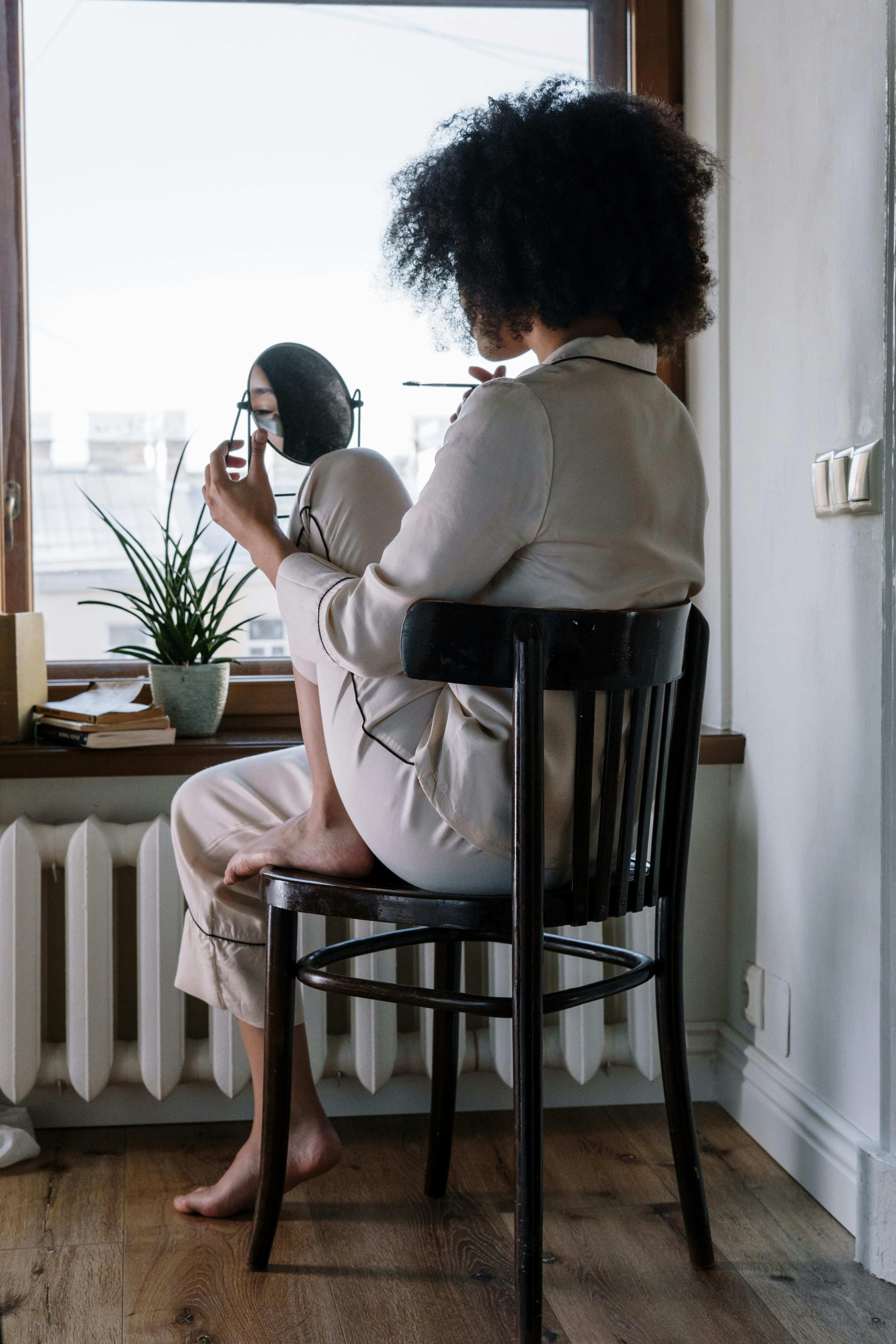 Una mujer en pijama mientras se mira en un espejo | Fuente: Pexels