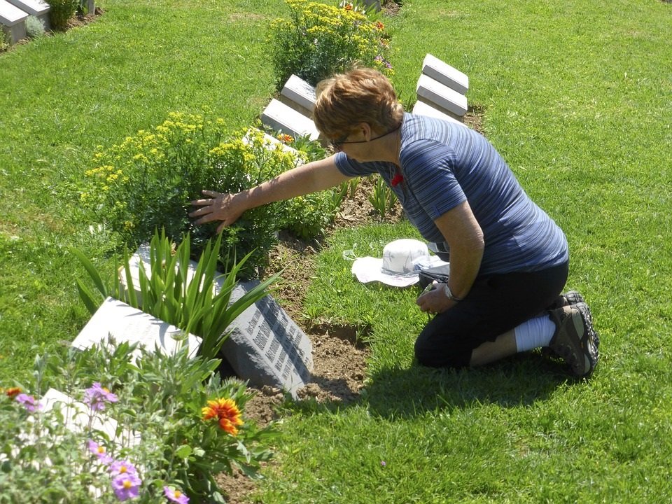 Mujer llorando arrodillada frente a una tumba. | Imagen: Max Pixel