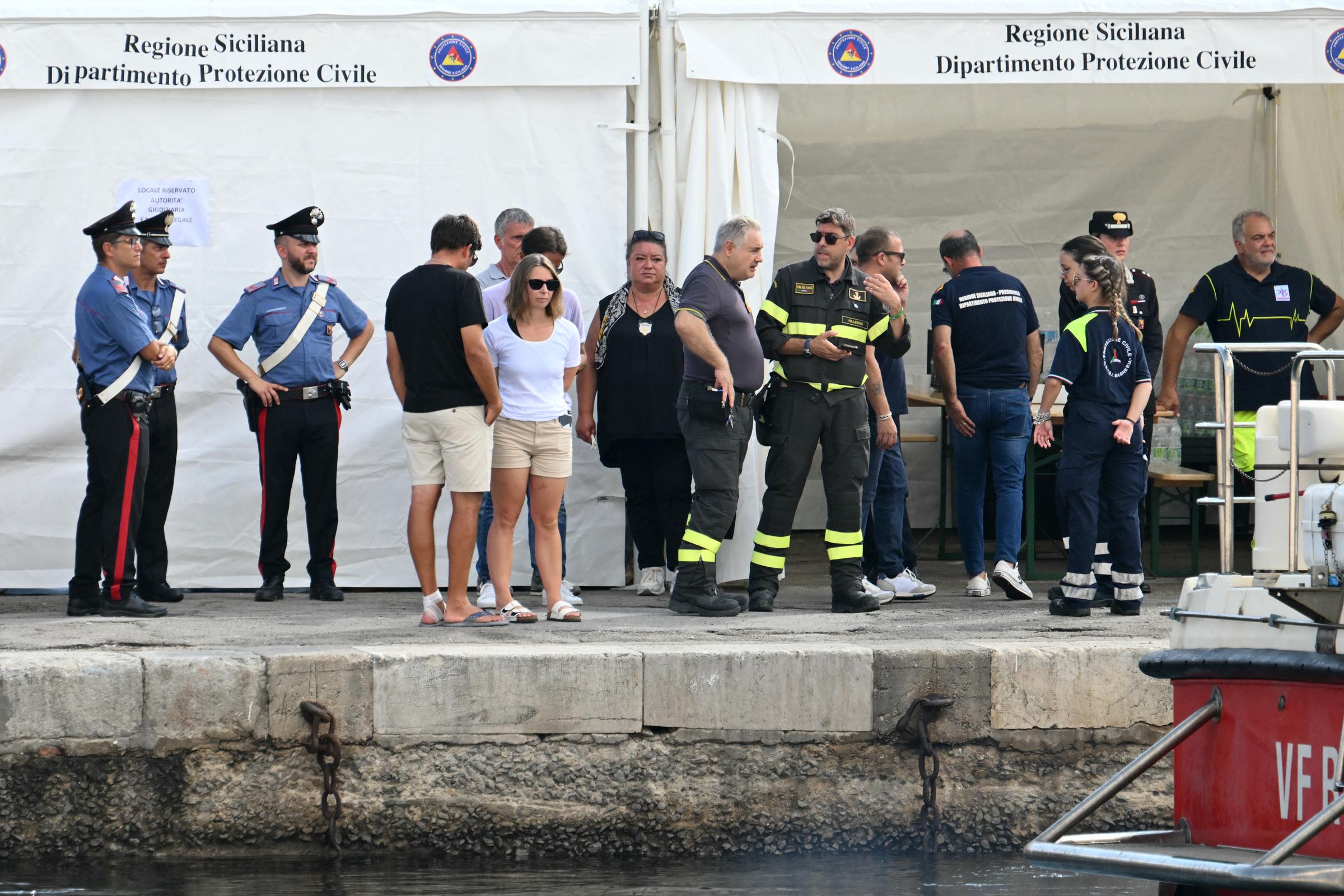 Varias personas permanecen junto a las autoridades locales y los equipos de rescate en el muelle de Porticello, cerca de Palermo, el 22 de agosto de 2024 | Fuente: Getty Images