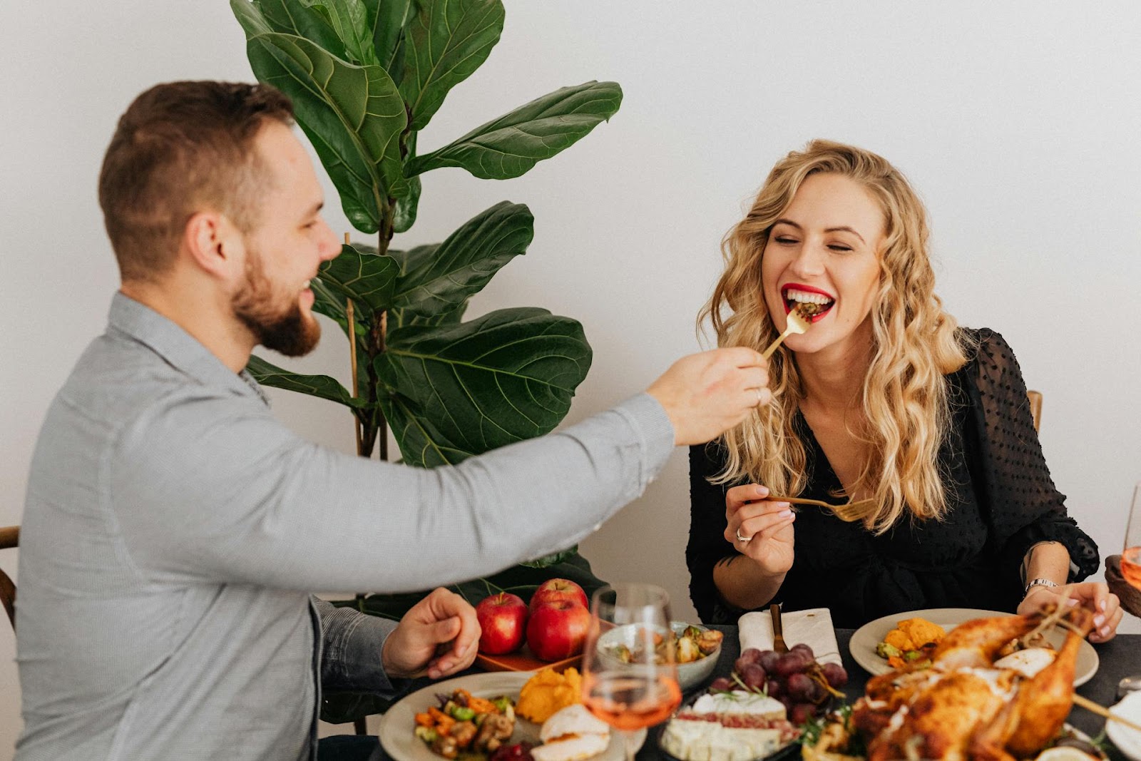 Un marido dando de comer a su mujer durante una cena casera | Fuente: Pexels