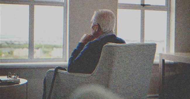 Un hombre mayor sentado mirando por una ventana | Foto: Shutterstock