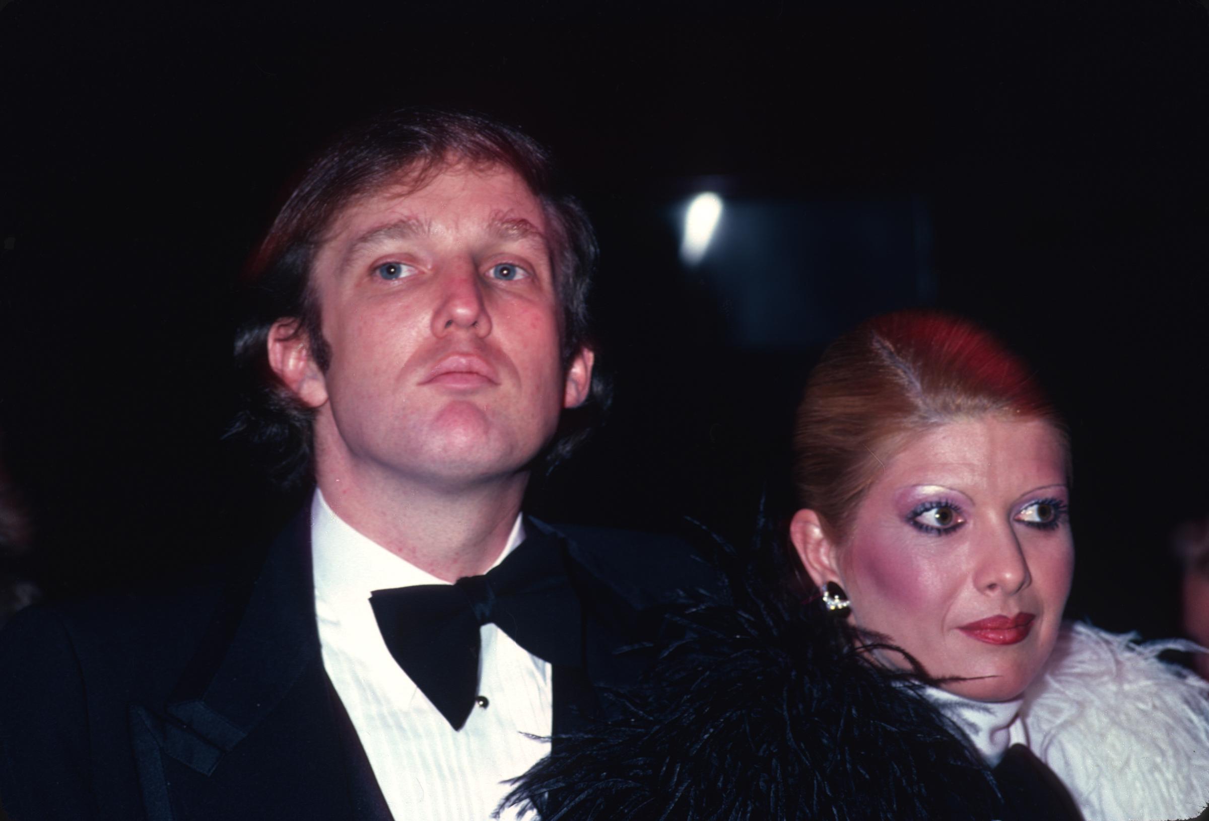 Donald Trump luce una melena abundante de color castaño oscuro mientras asiste a la fiesta de cumpleaños de Roy Cohn junto a su entonces Esposa, Ivana Trump, en Nueva York, en febrero de 1980.