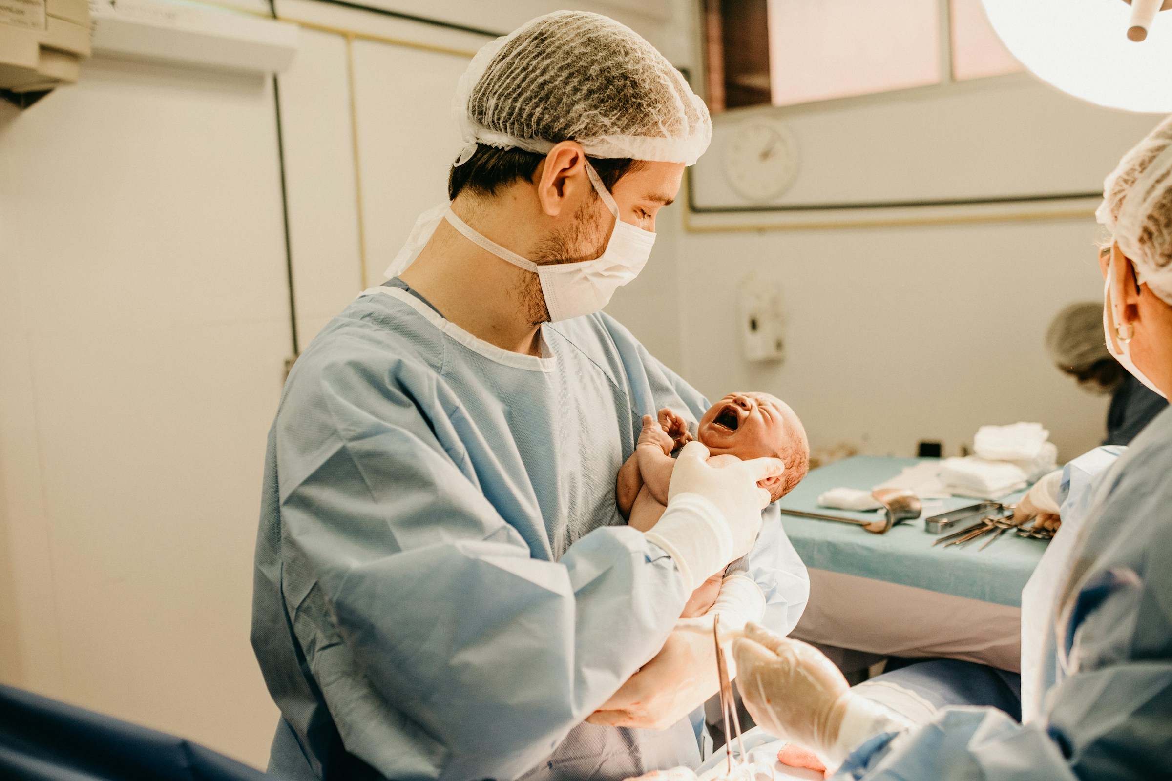 Un hombre con un bebé recién nacido en brazos | Foto: Unsplash