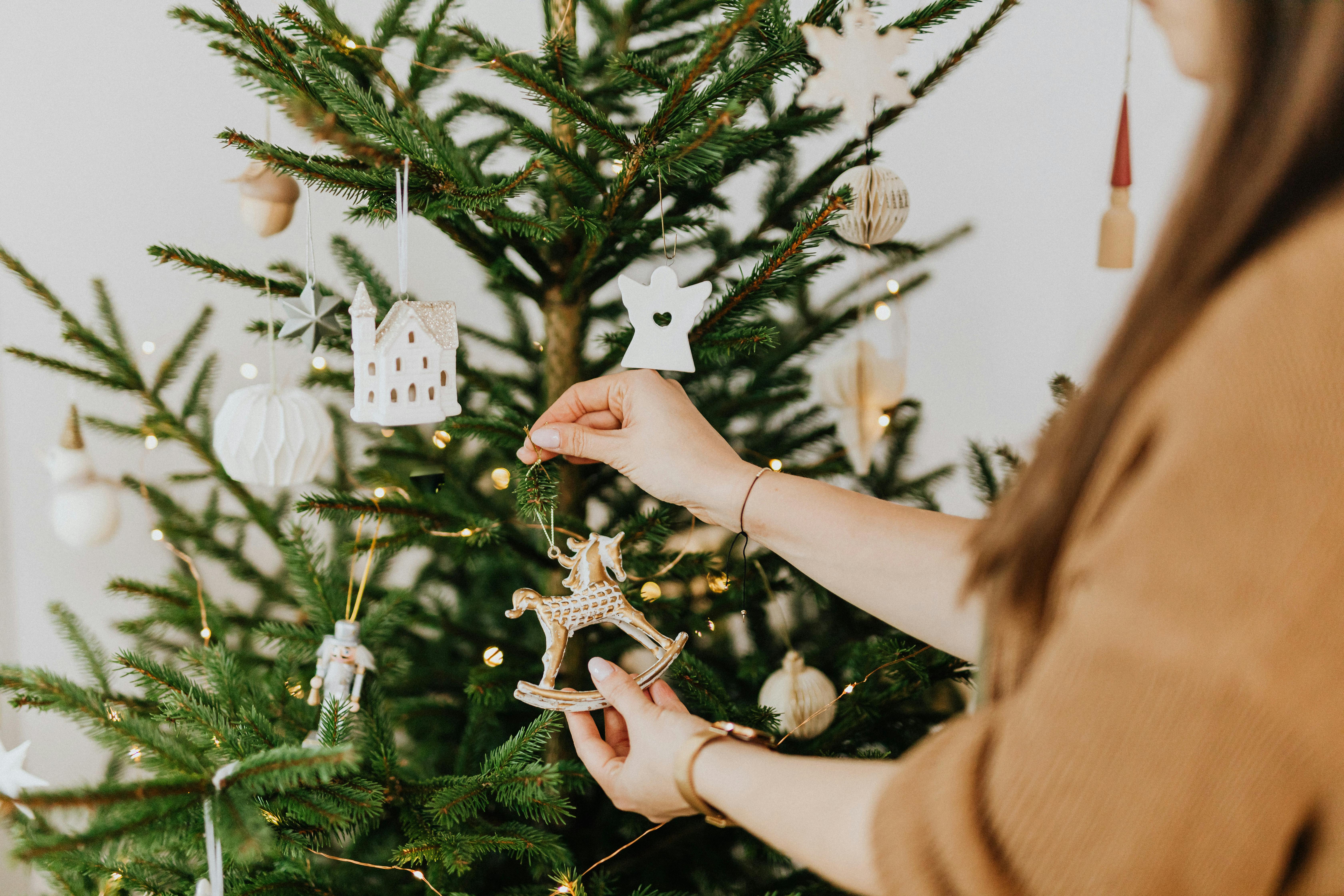 Una mujer decorando un árbol de Navidad | Fuente: Pexels