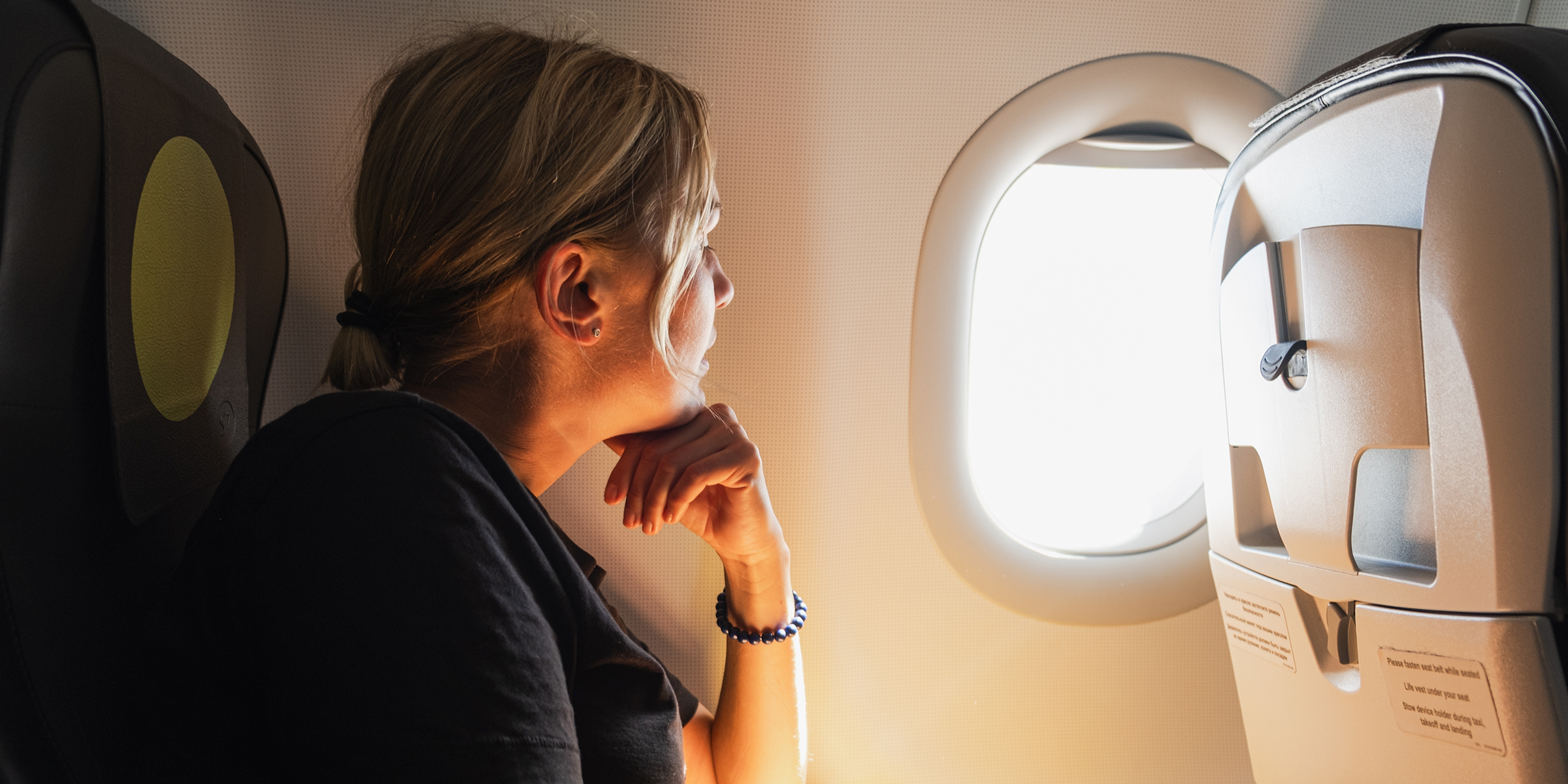 Una mujer sentada en un avión | Fuente: Shutterstock