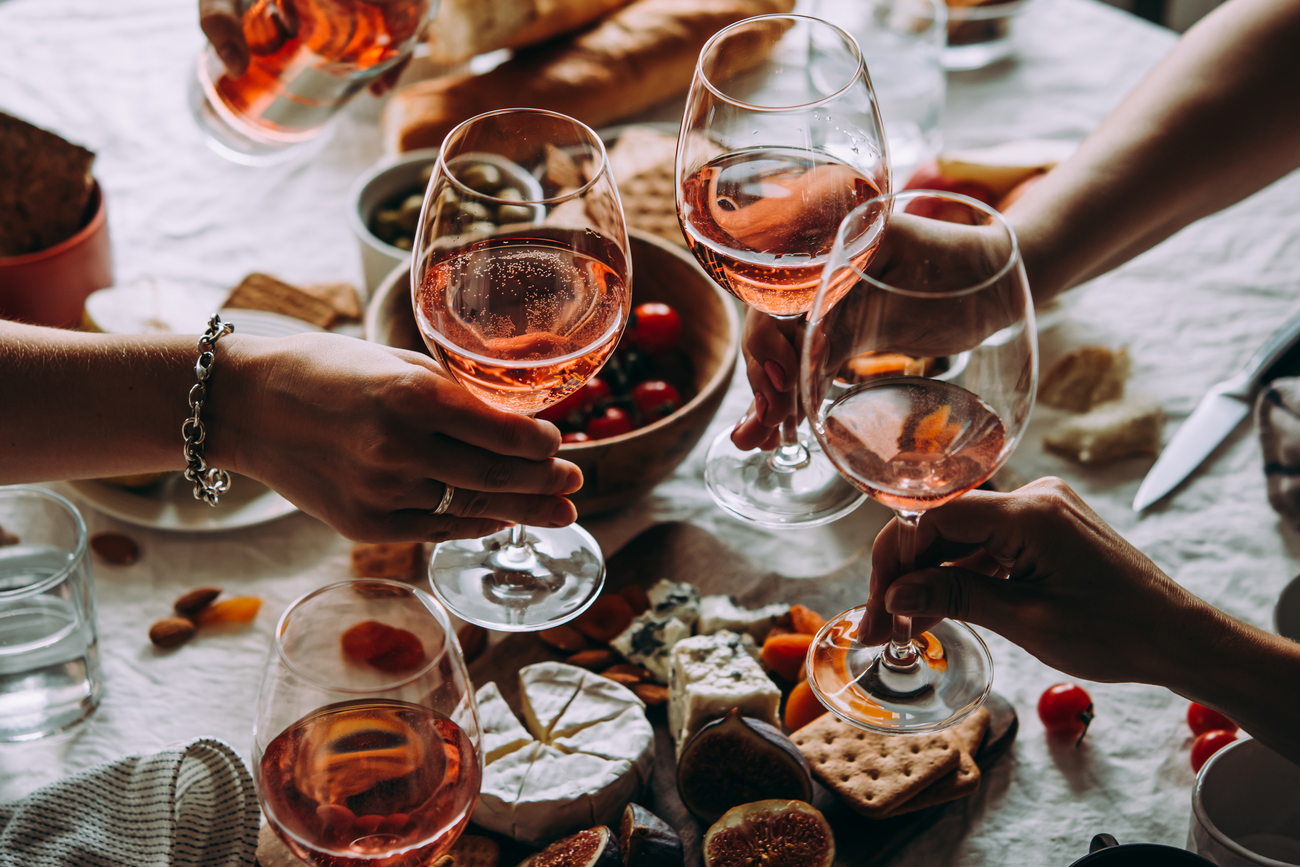 Gente sujetando copas de vino durante una fiesta | Foto: Shutterstock