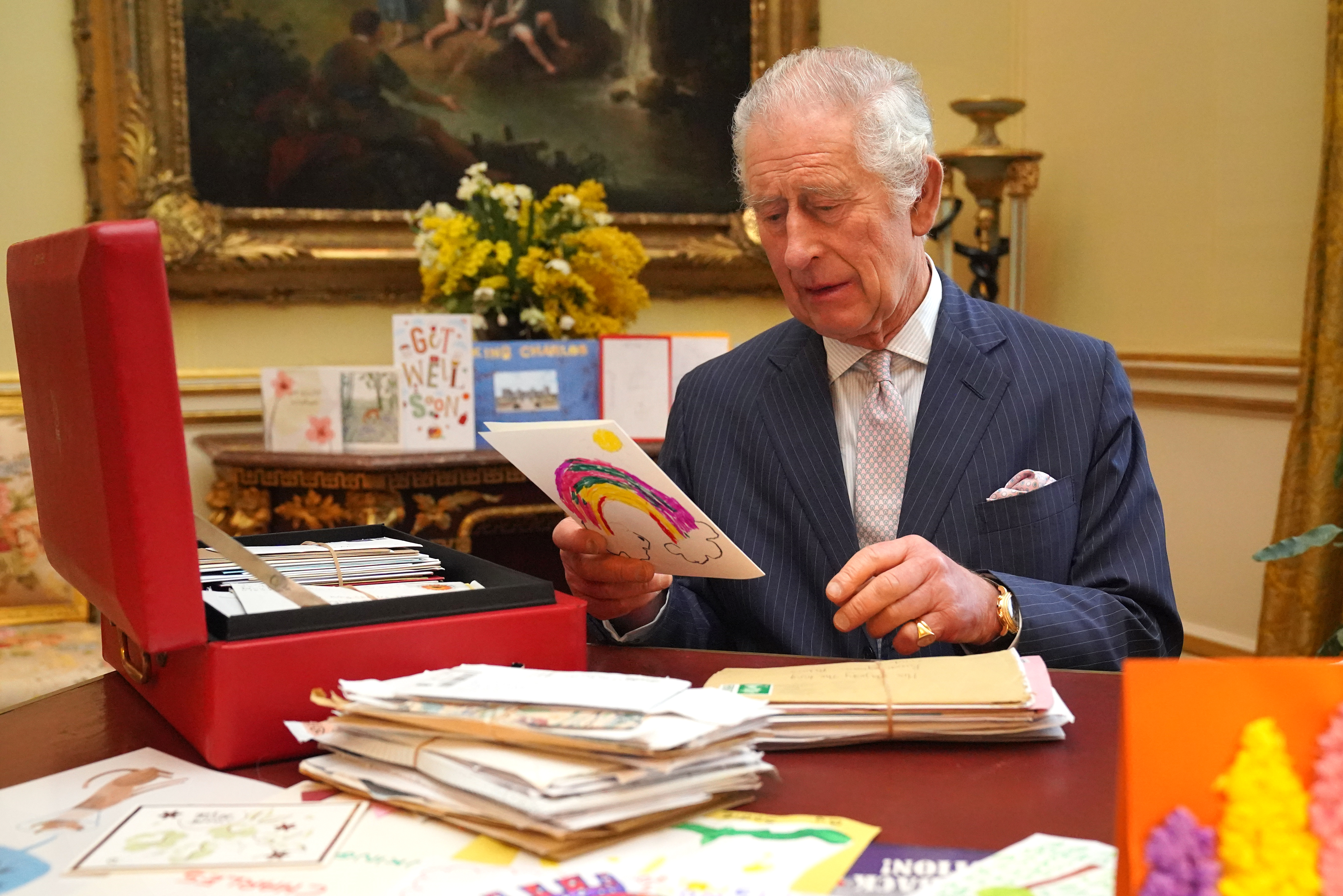 El rey Charles leyendo las tarjetas enviadas por los simpatizantes tras su diagnóstico de cáncer, en la Sala del Siglo XVIII de la Suite Belga del Palacio de Buckingham el 21 de febrero de 2024 en Londres, Inglaterra | Foto: Getty Images