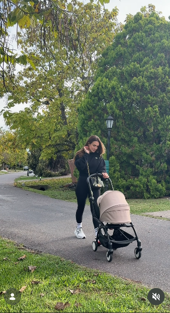 Camila Homs dio un paseo al aire libre mientras empujaba el cochecito de bebé con capota beige a lo largo de un sendero arbolado. Para la caminata, la modelo optó por un conjunto deportivo total black compuesto por un buzo holgado y calzas ajustadas, que combinó con zapatillas deportivas blancas y medias altas. | Fuente: Instagram/camihoms