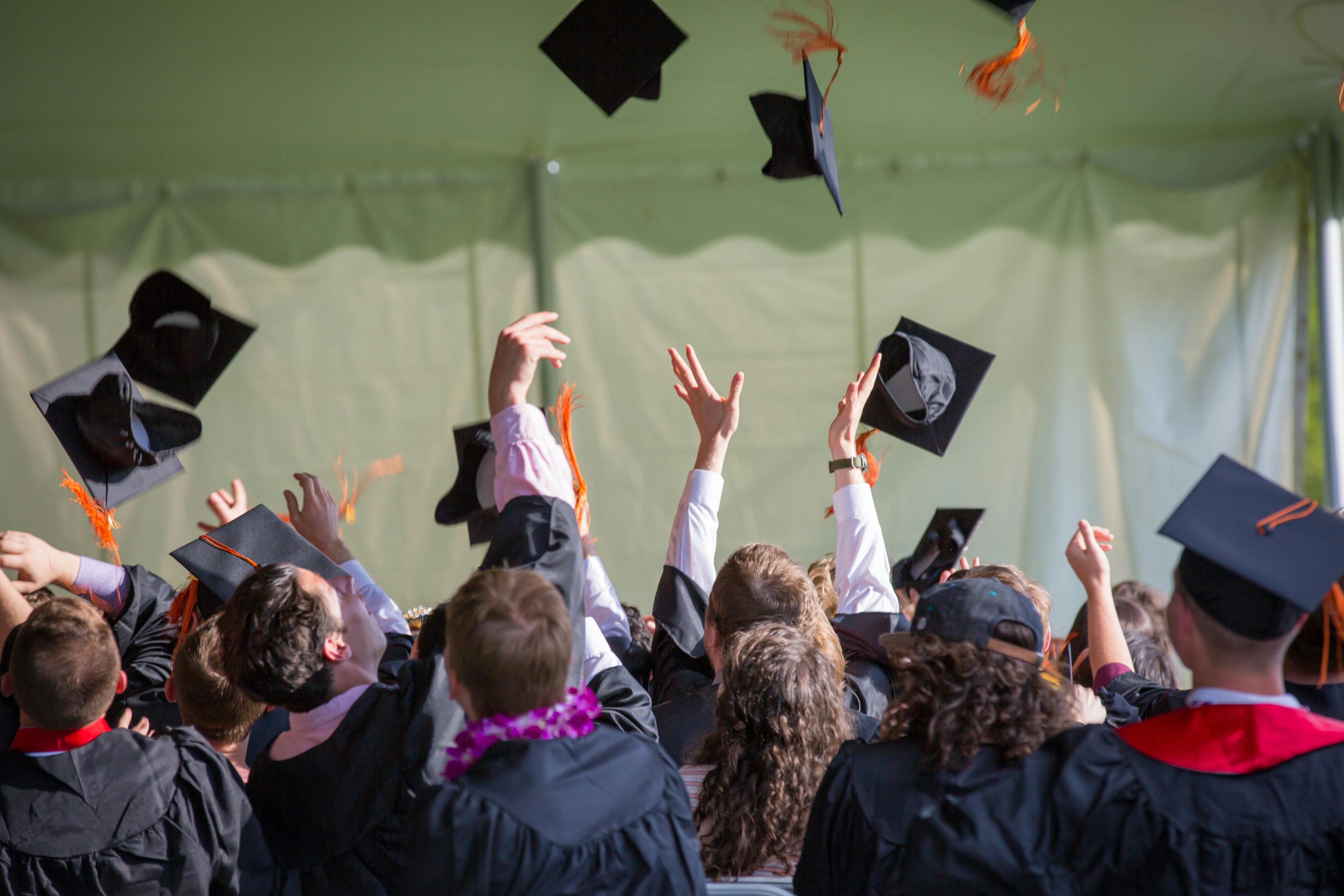 Un grupo de estudiantes lanzando al aire sus birretes de graduación | Foto: Pexels