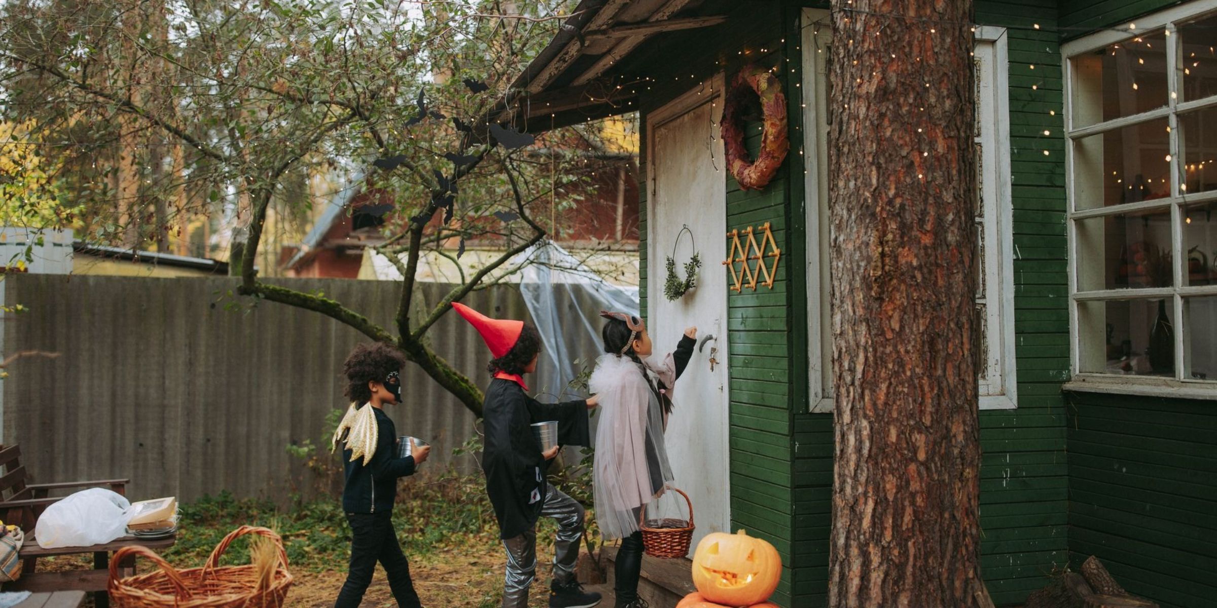 Niños con disfraces de Halloween pidiendo caramelos en una casa decorada | Fuente: Pexels