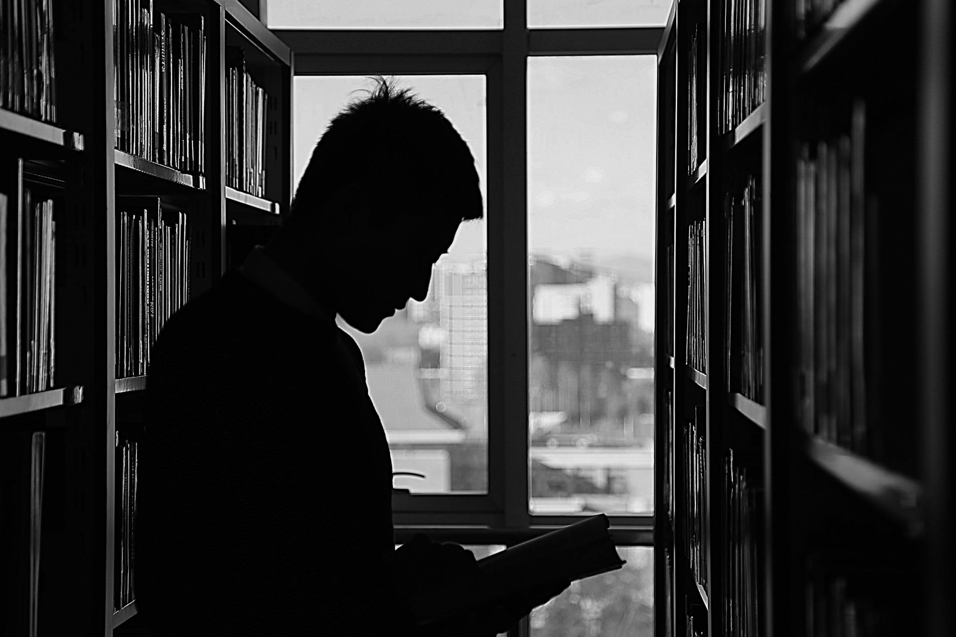 Silueta de un hombre en una biblioteca | Fuente: Pexels