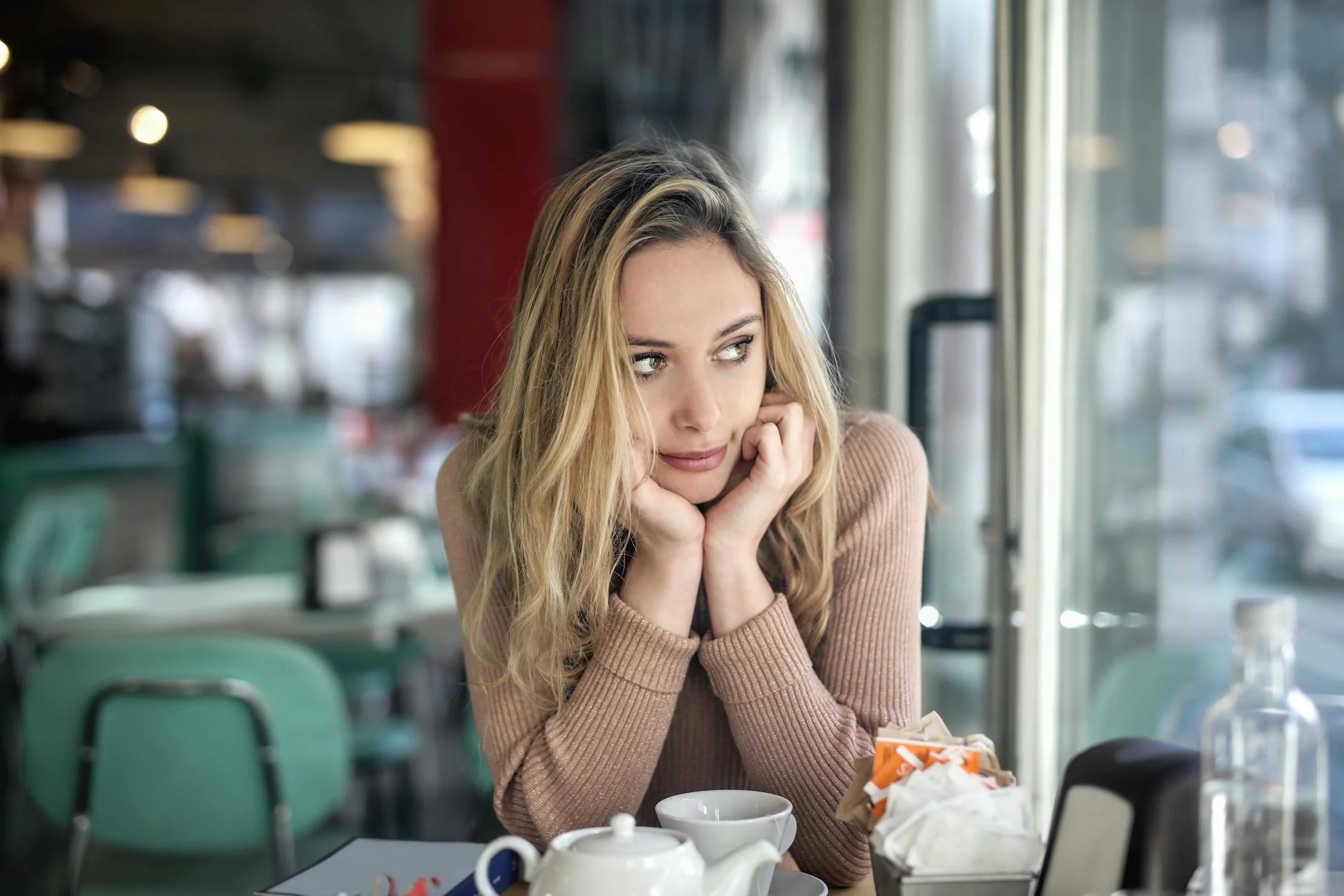 Una mujer mirando a su lado en una cafetería | Fuente: Pexels