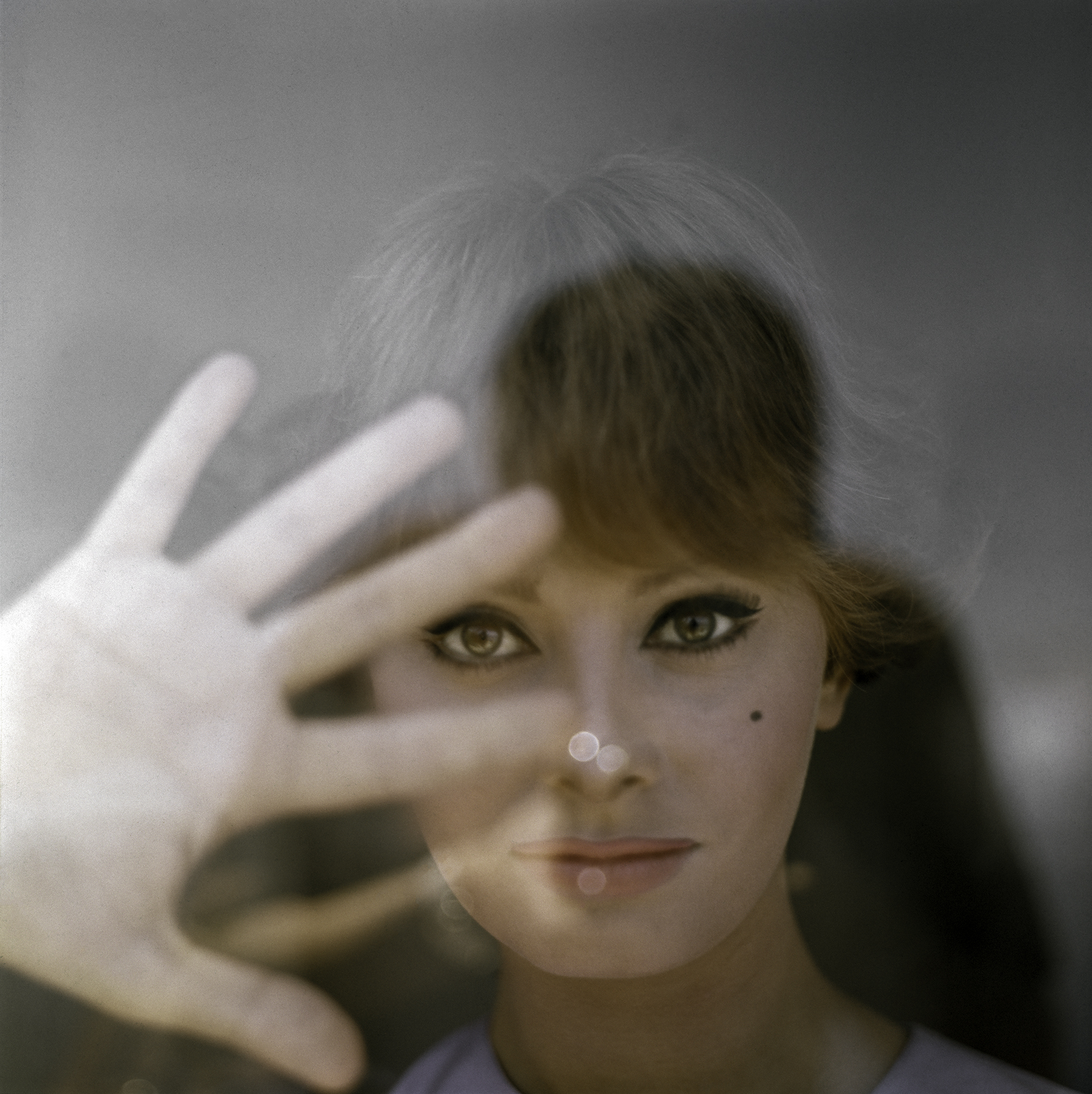La actriz italiana Sophia Loren mirando a través del cristal de una ventana con la mano derecha hacia arriba, ciudad de Nueva York, EE. UU., 1954.