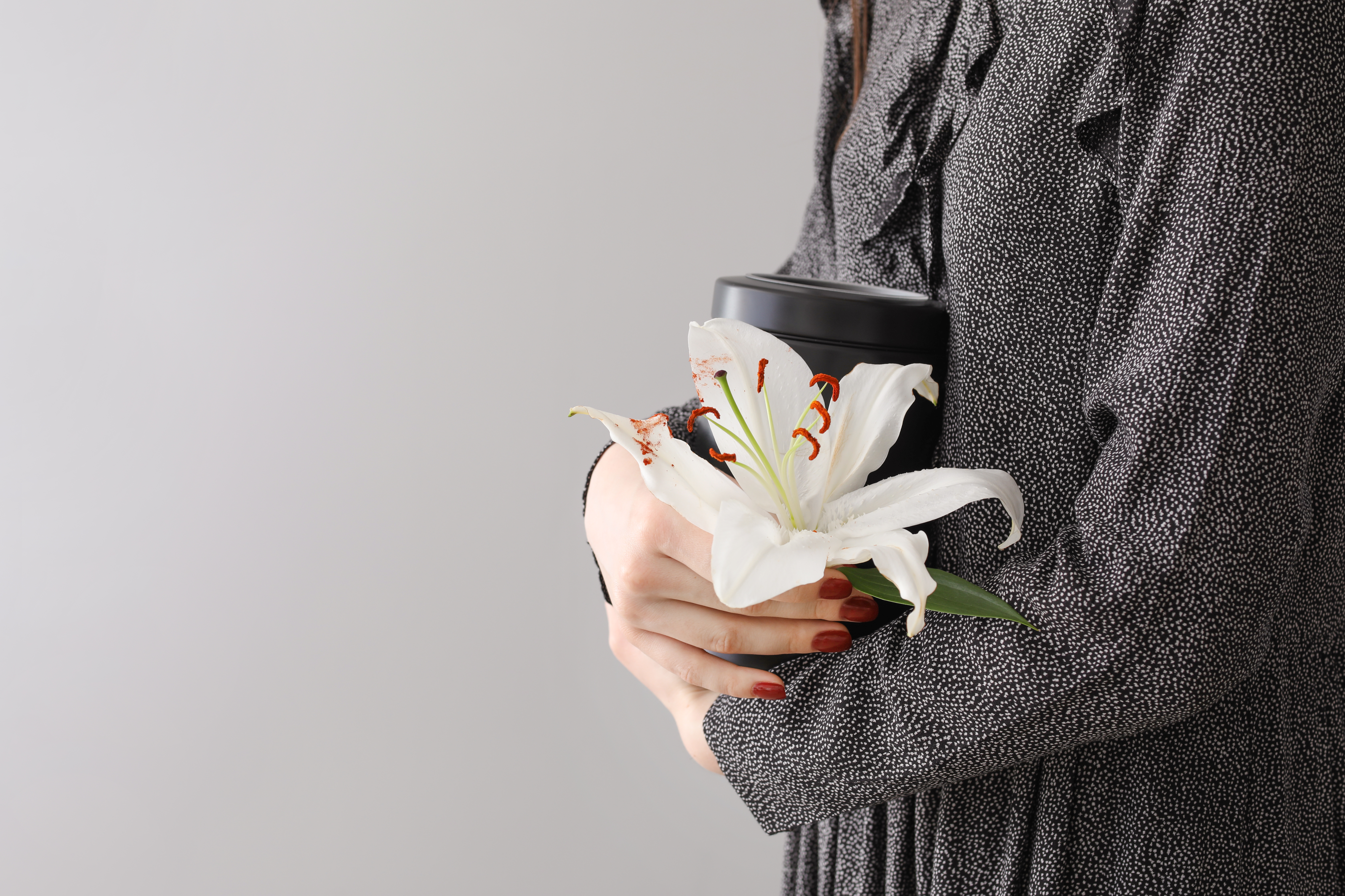 Mujer sosteniendo una urna y una flor de lis | Foto: Shutterstock