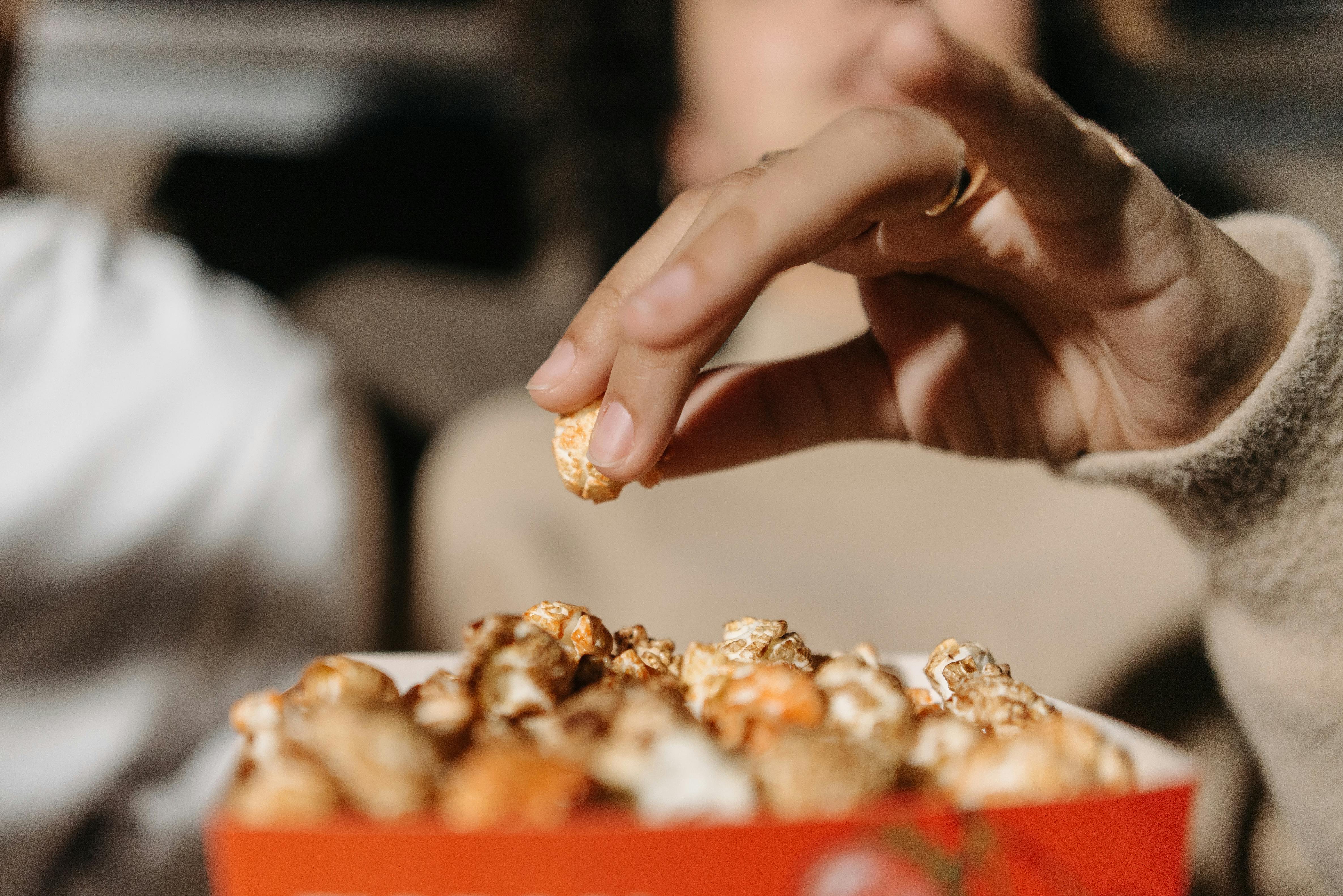 Una mujer comiendo palomitas | Fuente: Pexels