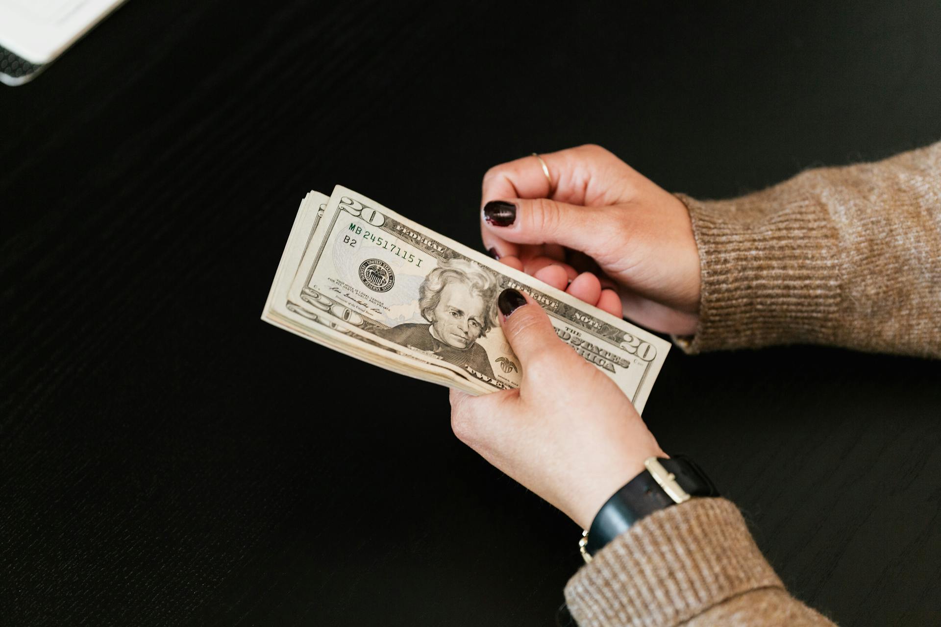 Una mujer con dinero en la mano | Fuente: Pexels