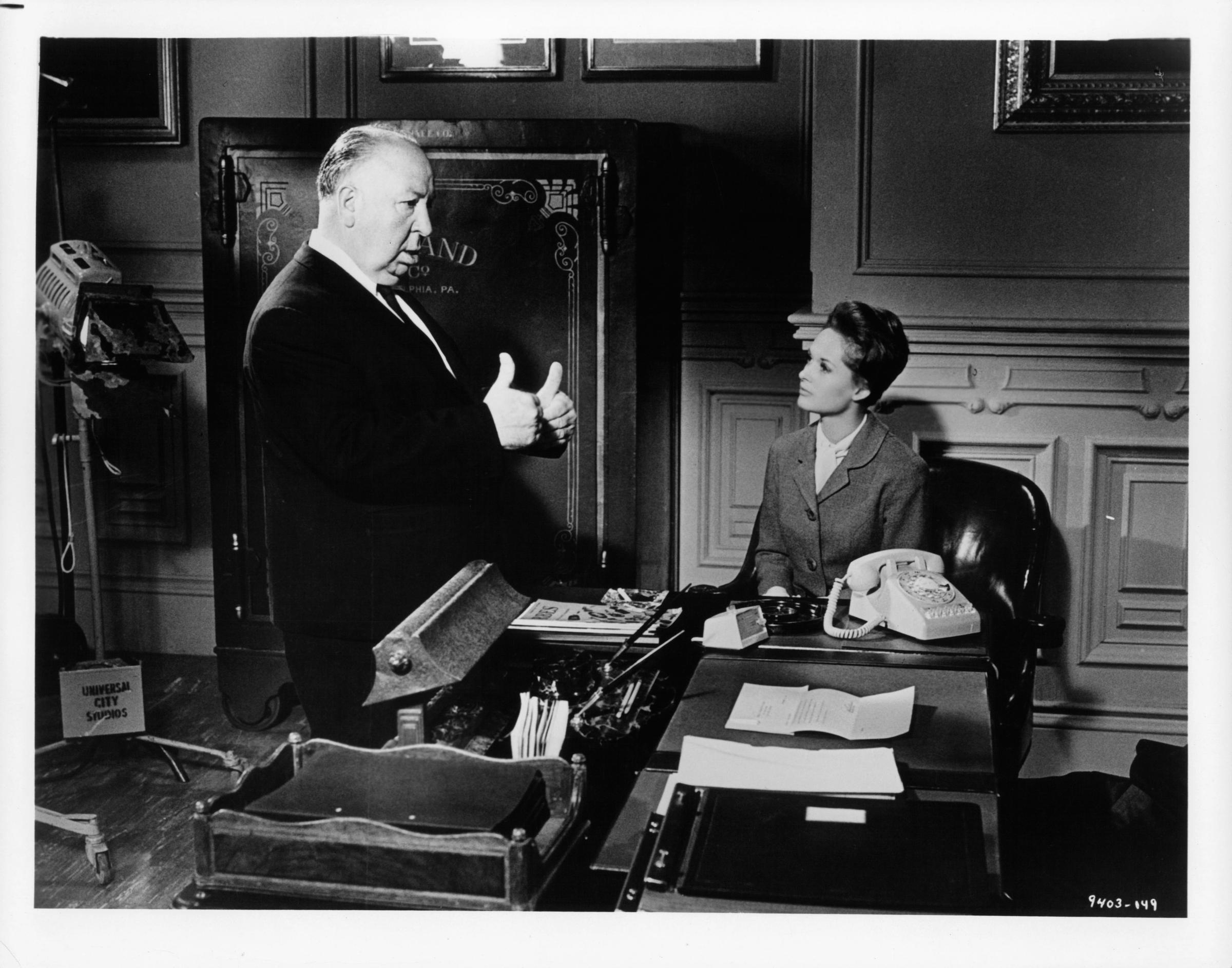 Alfred Hitchcock da indicaciones a Tippi Hedren entre escenas de la película "Marnie" en 1964. | Fuente: Getty Images