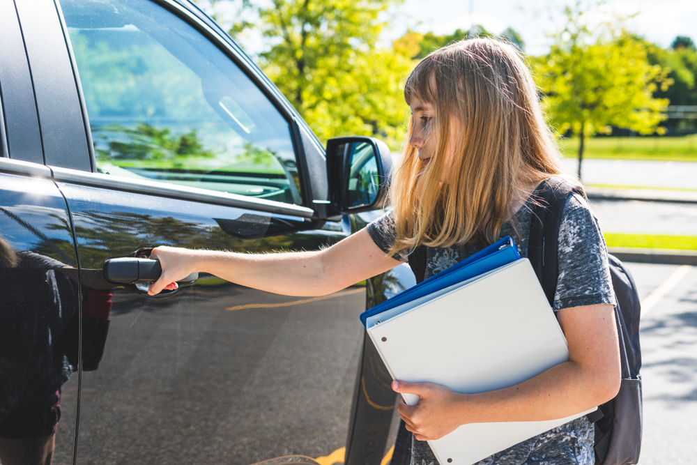 Una adolescente junto a un Automóvil | Foto: Shutterstock