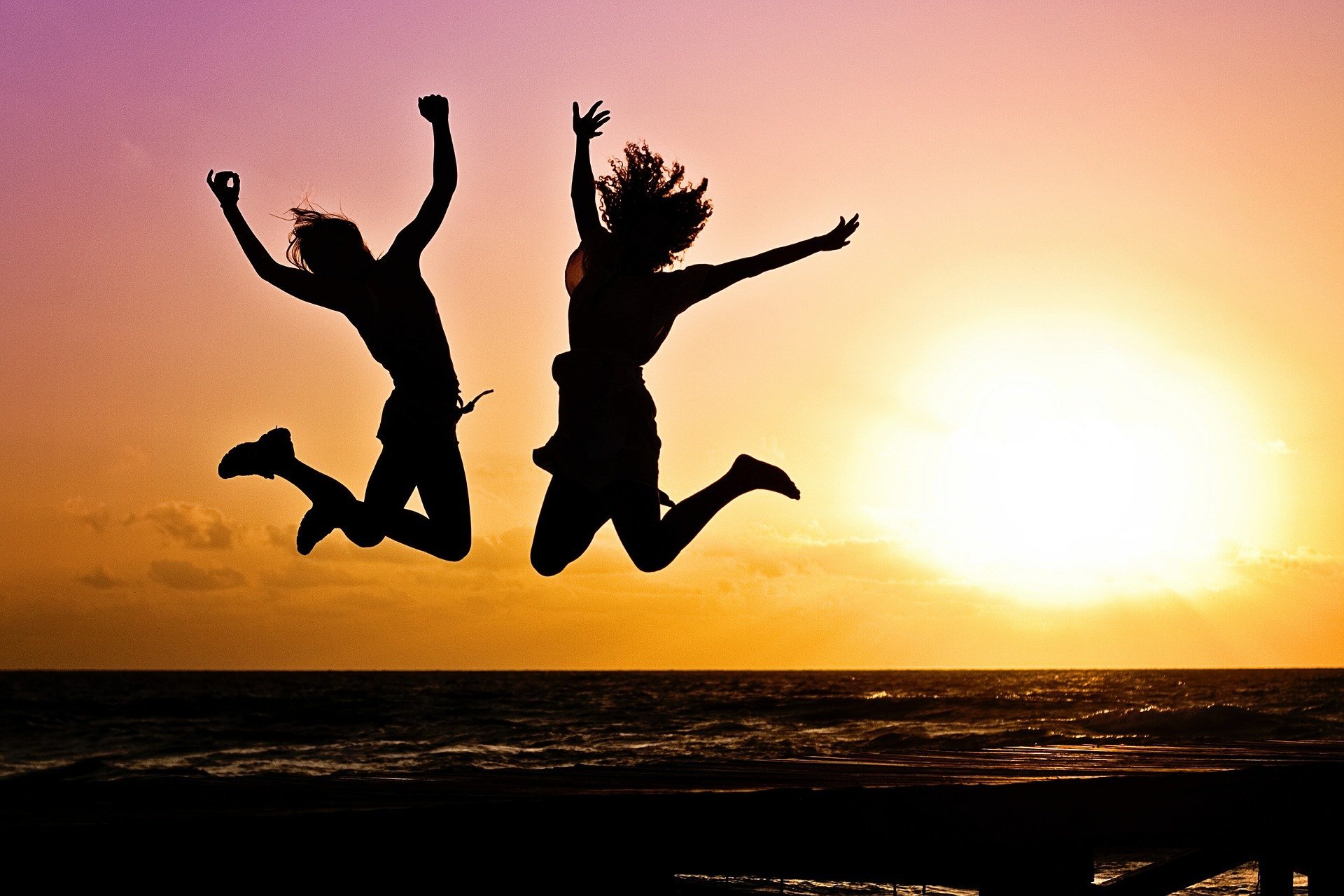 Mujeres felices saltando frente al atardecer. | Foto: Pixabay