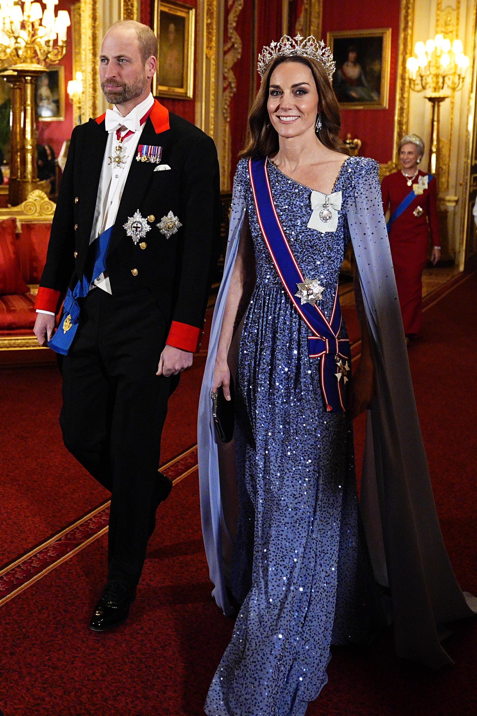 El príncipe William y Catherine, princesa de Gales, llegan al banquete de Estado en honor al presidente alemán Frank-Walter Steinmeier y su esposa, Elke Büdenbender, en el castillo de Windsor el 3 de diciembre de 2025. Catherine deslumbra con un vestido azul lavanda de lentejuelas de Jenny Packham, con capa abierta hasta el suelo, la tiara Strathmore Rose de la reina madre, la banda de la Real Orden Victoriana y la Orden de la Familia Real del rey Charles III. William viste frac formal de Windsor con condecoraciones ceremoniales. | Fuente: Getty Images