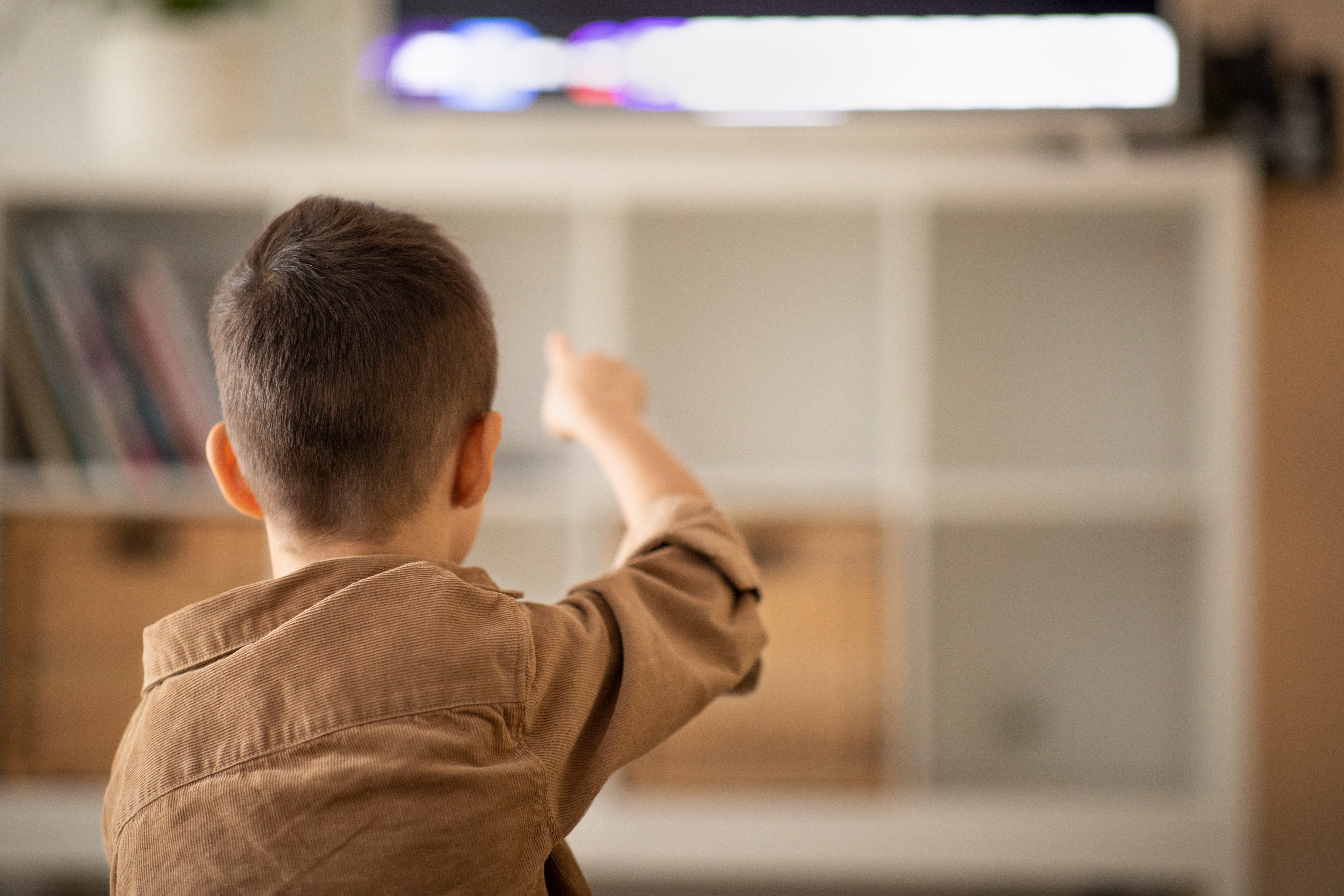 Niño pequeño señalando con el dedo al televisor | Foto: Shutterstock