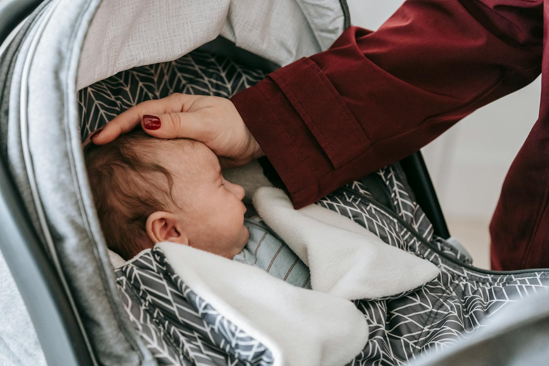 Una madre admirando a su bebé dormido en el cochecito | Fuente: Pexels