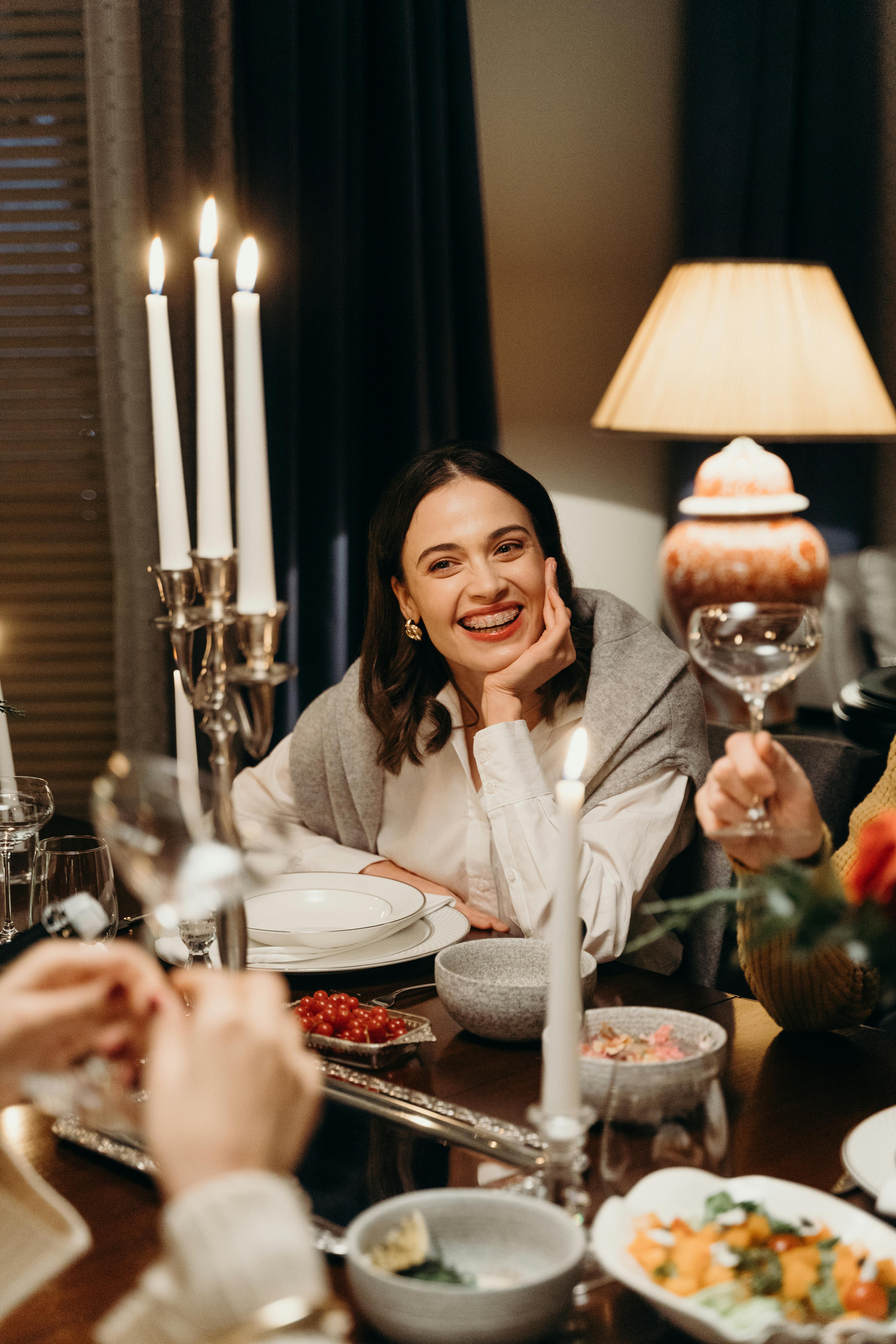 Una mujer sonriente en la mesa | Fuente: Pexels