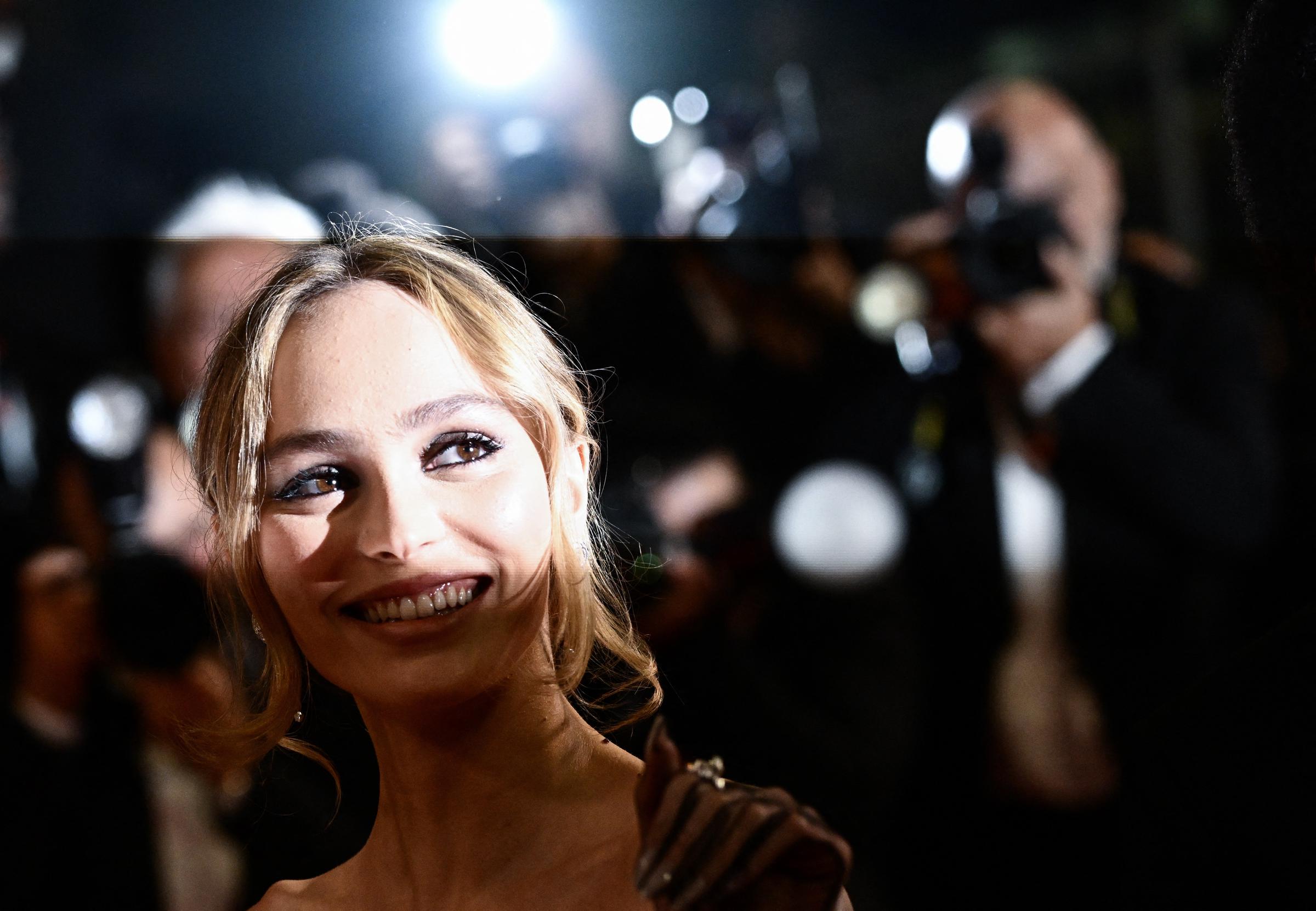 Lily-Rose Depp sonríe ante los fotógrafos en el Festival de Cannes el 22 de mayo de 2023, durante una proyección de "The Idol". La actriz ha expresado su deseo de que sus actuaciones definan su imagen pública, en lugar de sus antecedentes familiares. | Fuente: Getty Images
