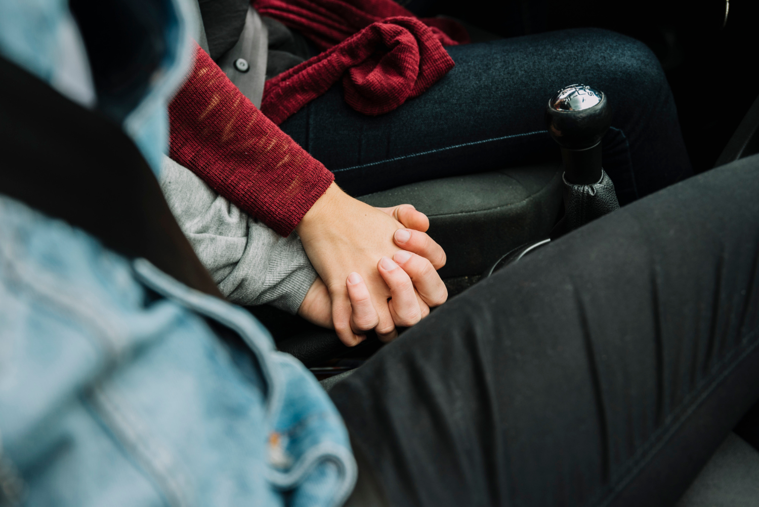 Una pareja sentada en el automóvil y tomada de la mano | Fuente: Freepik