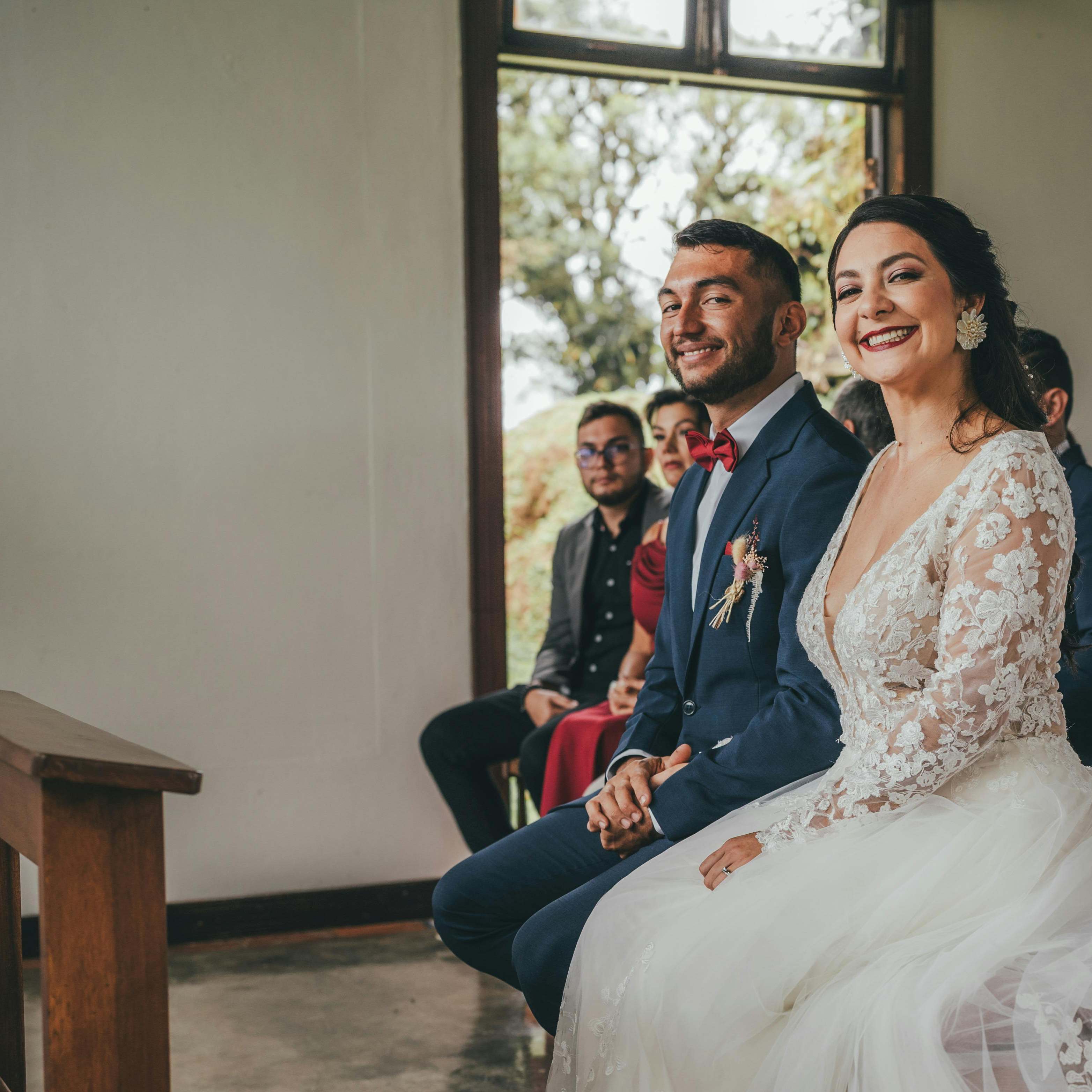 Unos novios sonriendo ante el altar | Fuente: Pexels