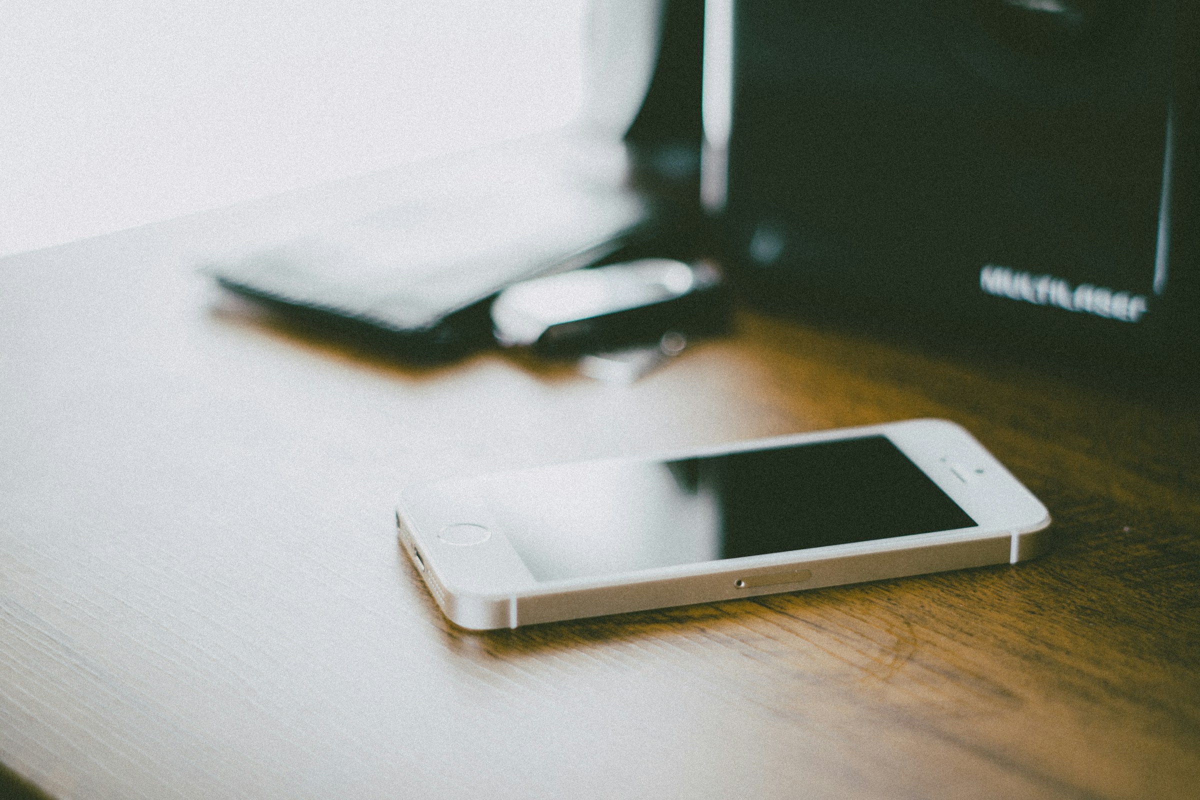 Un smartphone sobre una mesa de madera marrón | Fuente: Unsplash