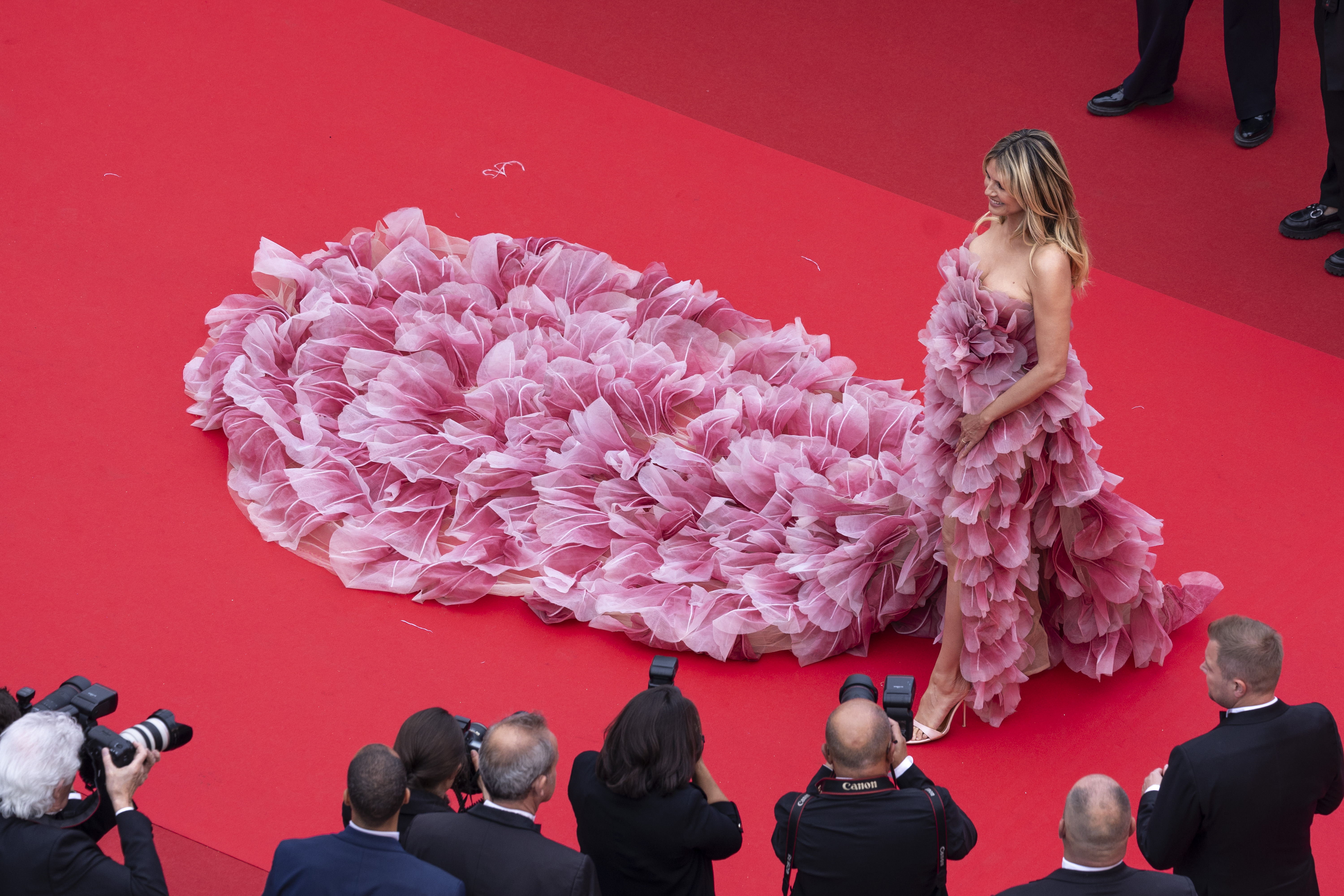 Una toma aérea ofrece una sorprendente vista del vestido de Klum desde arriba, revelando sutilmente su escote como parte del intrincado diseño del vestido.