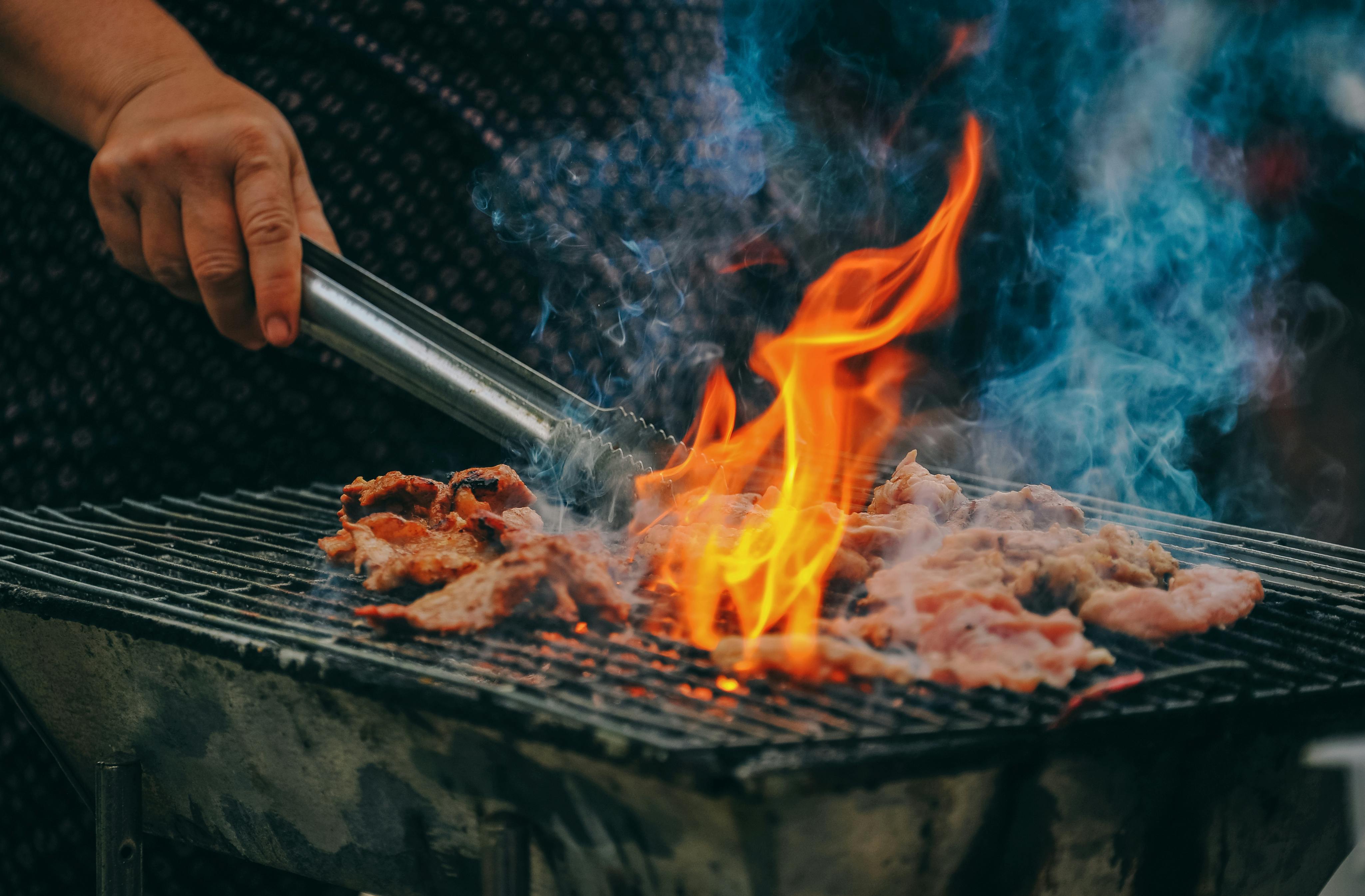 Primer plano de un hombre cocinando carne | Fuente: Pexels