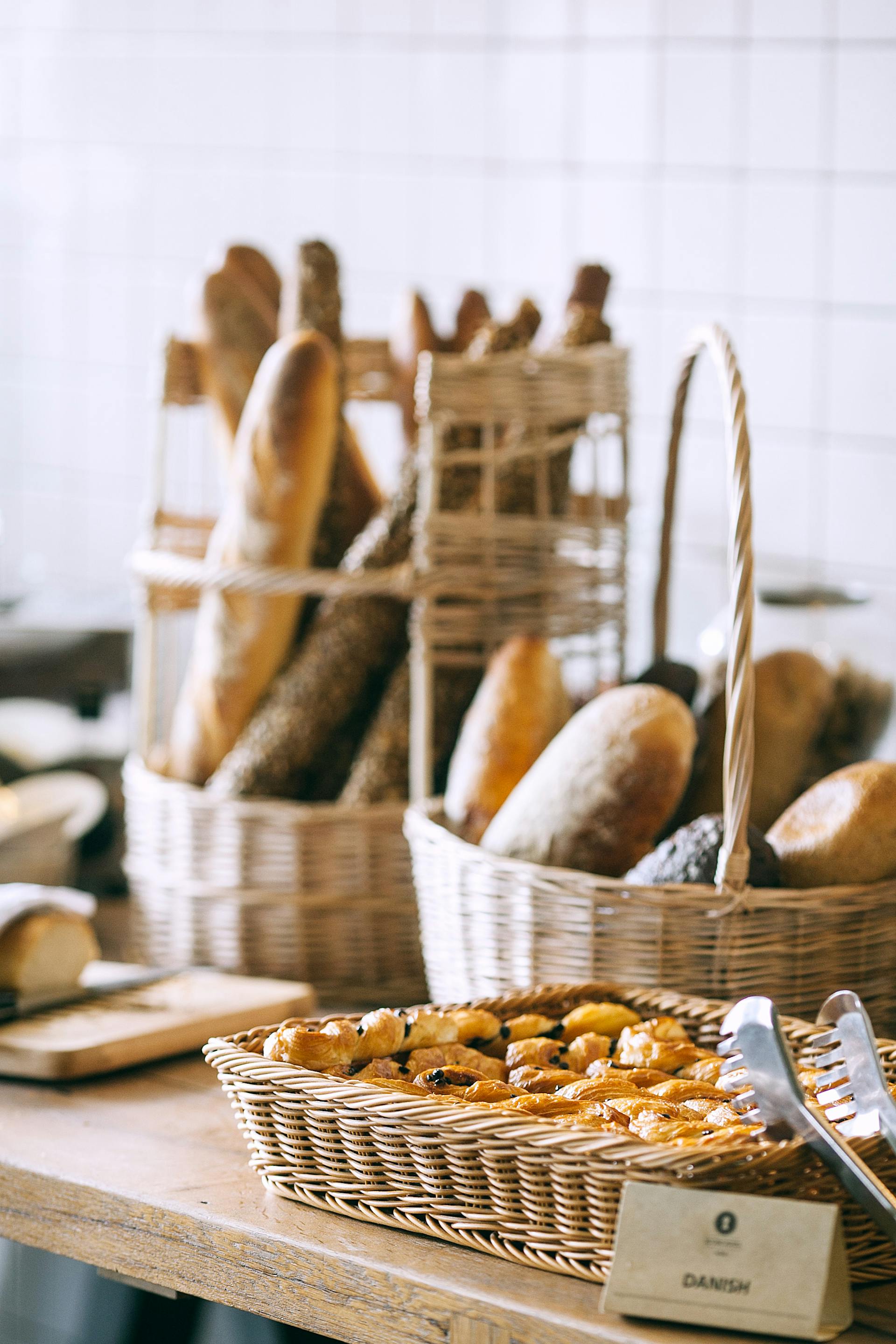 Una colección de pan y bollos horneados en una panadería | Fuente: Pexels