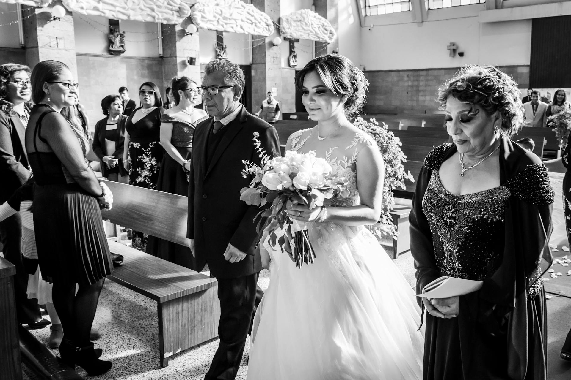 Toma en escala de grises de una novia encantada caminando hacia el altar | Fuente: Pexels