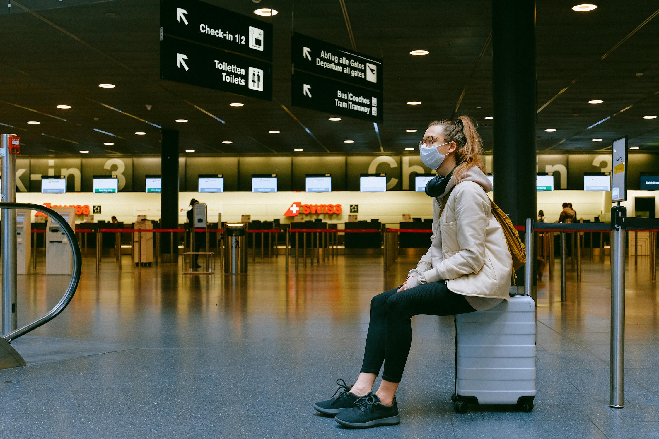 Una mujer sentada sobre una maleta | Fuente: Pexels