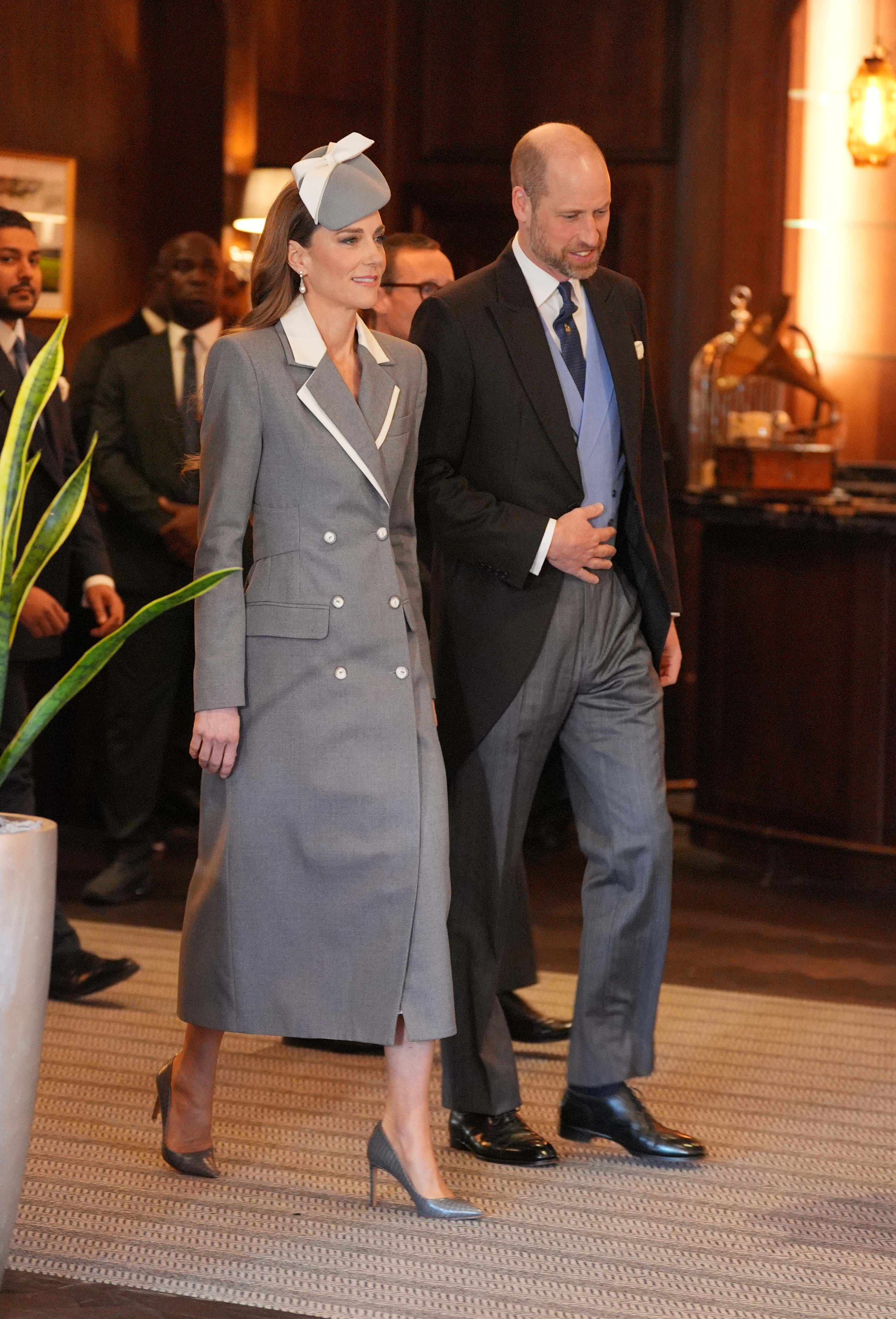 Catherine, princesa de Gales, llega junto al príncipe William al hotel Fairmont Windsor Park para recibir al presidente de Nigeria, Bola Ahmed Tinubu, y a la primera dama, Oluremi Tinubu, el 18 de marzo de 2026, al inicio de la visita de Estado. Catherine viste un abrigo entallado gris de doble botonadura, con solapas y botones blancos, sombrero tipo pastillero a juego con lazo y zapatos de tacón grises. | Fuente: Getty Images