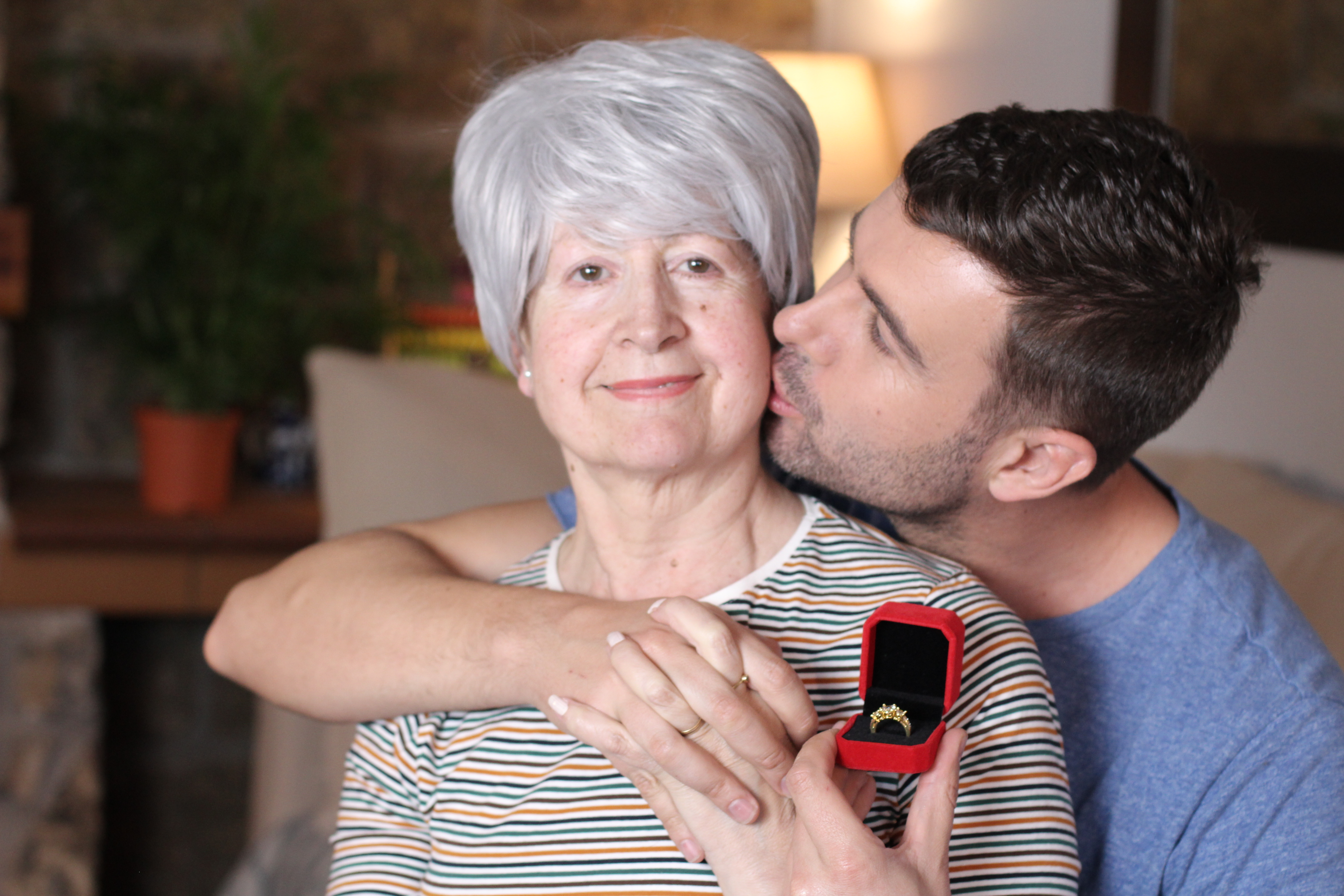 Un joven besa en la mejilla a una mujer mayor | Fuente: Shutterstock