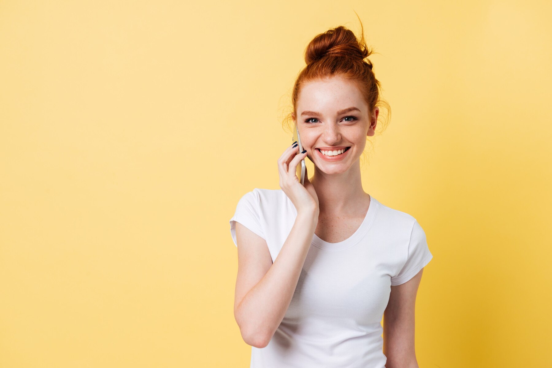 Una mujer pelirroja hablando por teléfono | Fuente: Freepik