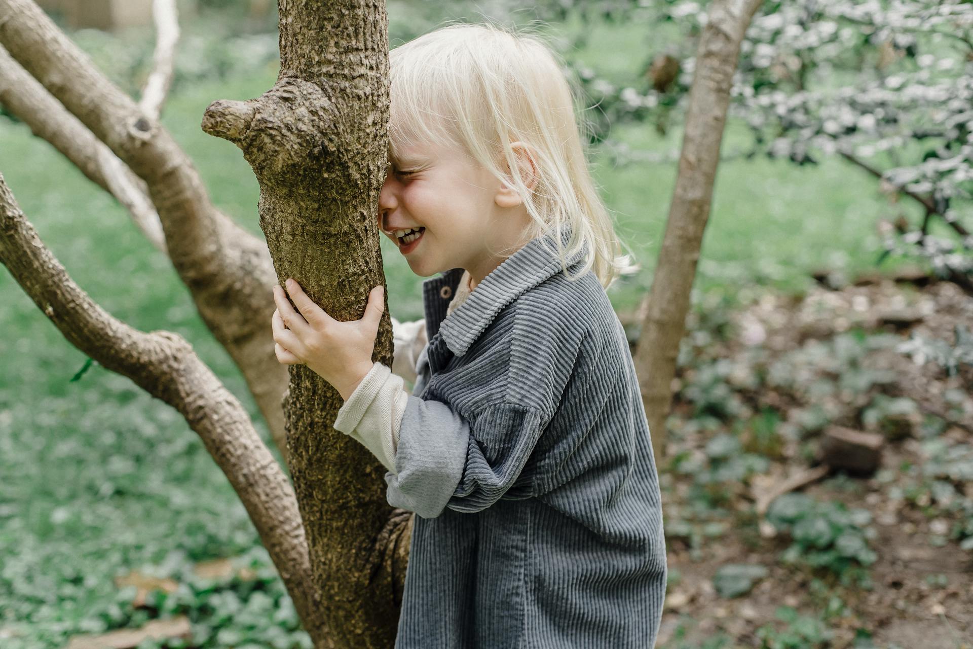 Un niño sujetando un árbol | Foto: Pexels
